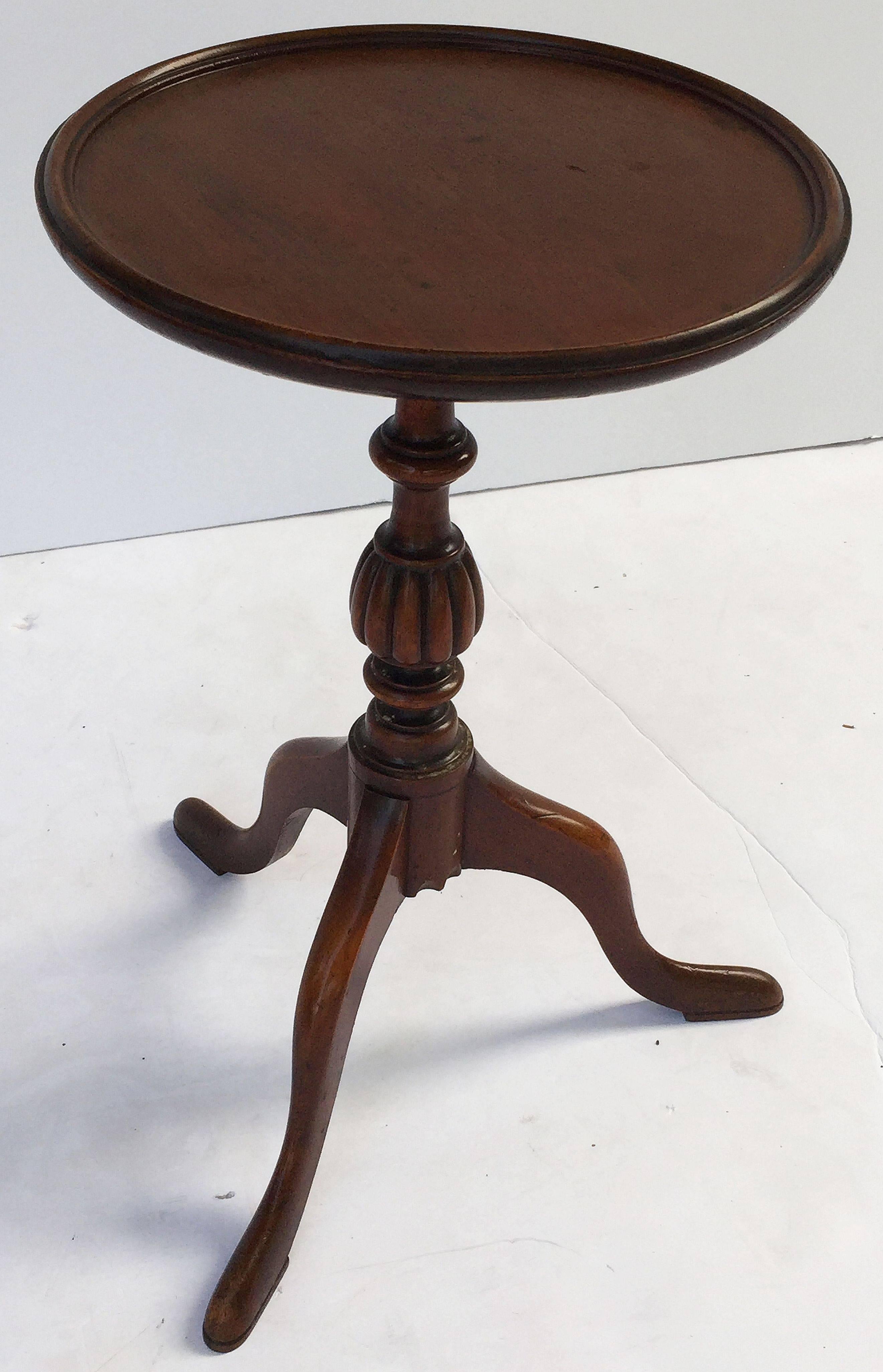 An English wine table of mahogany from the Edwardian era, featuring a raised edge around the circumference of the round, moulded top, mounted upon a turned column pedestal with tripod base. Set upon pad feet. 

An excellent choice as a side table