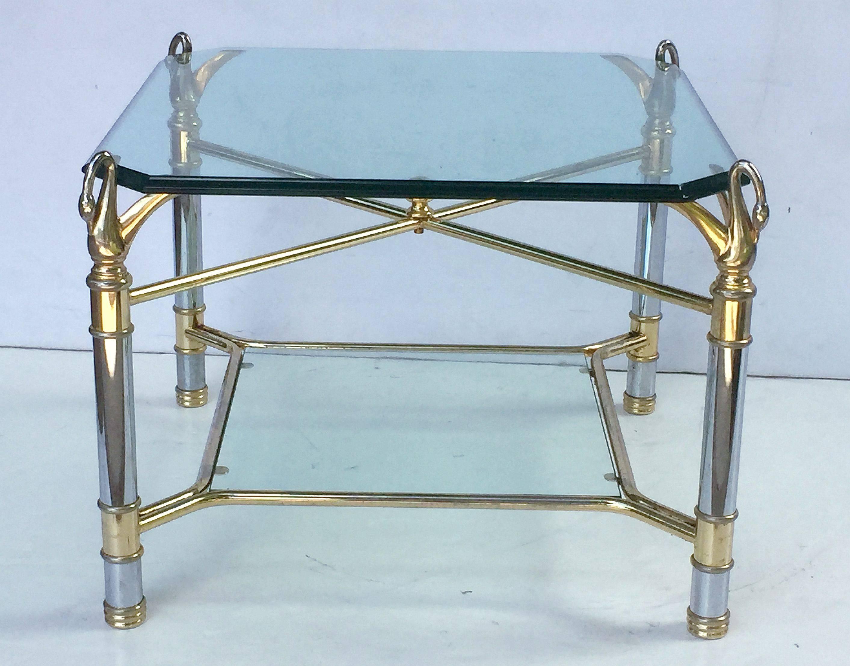 A fine French low table featuring a square canted and beveled edge clear glass top, set upon a chrome and gilt metal base with decorative swan's neck supports at each corner, with lower tier inset clear glass stretcher base.

Makes a great cocktail