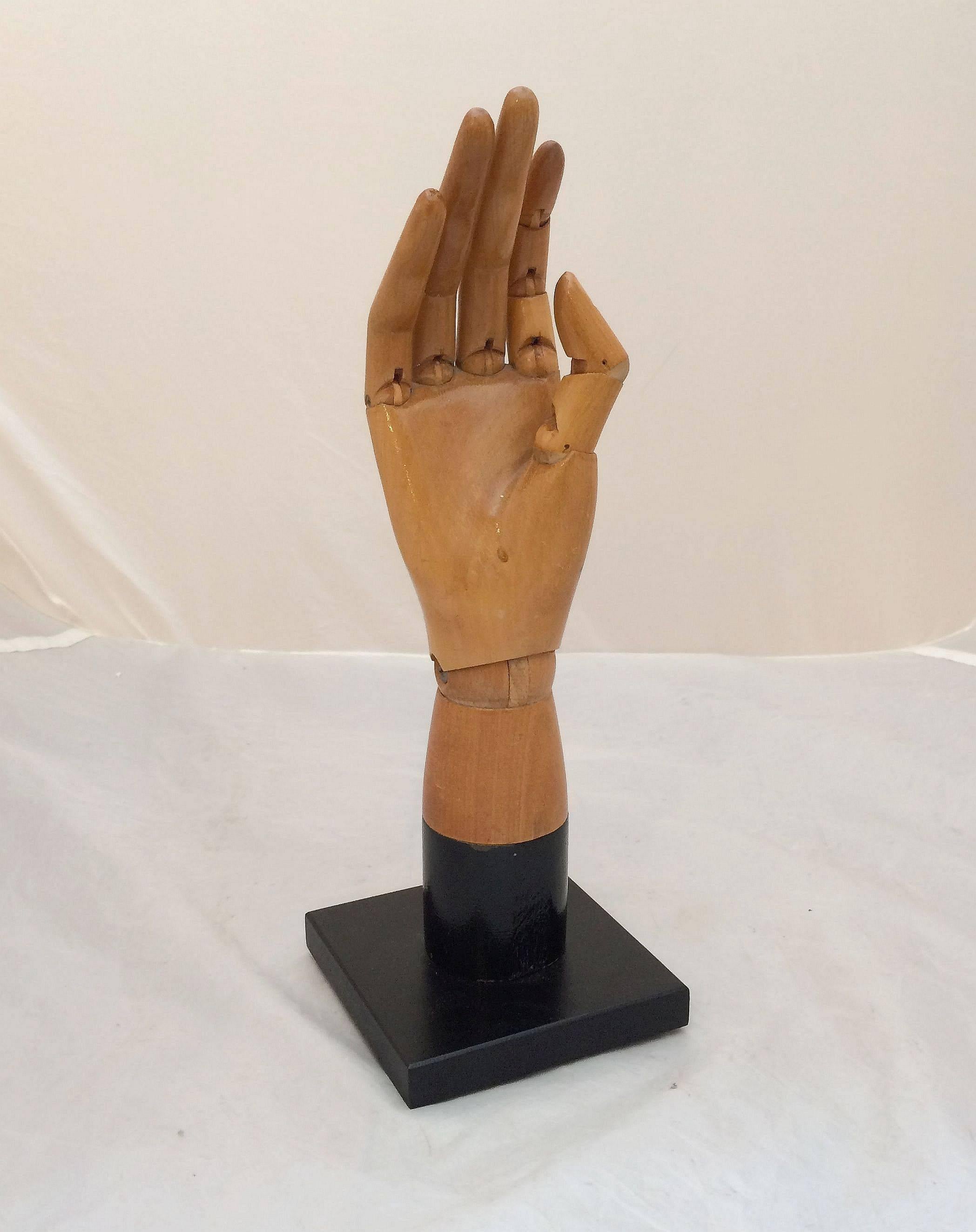 A fine English articulating model of a hand, mounted to an ebonized square base.