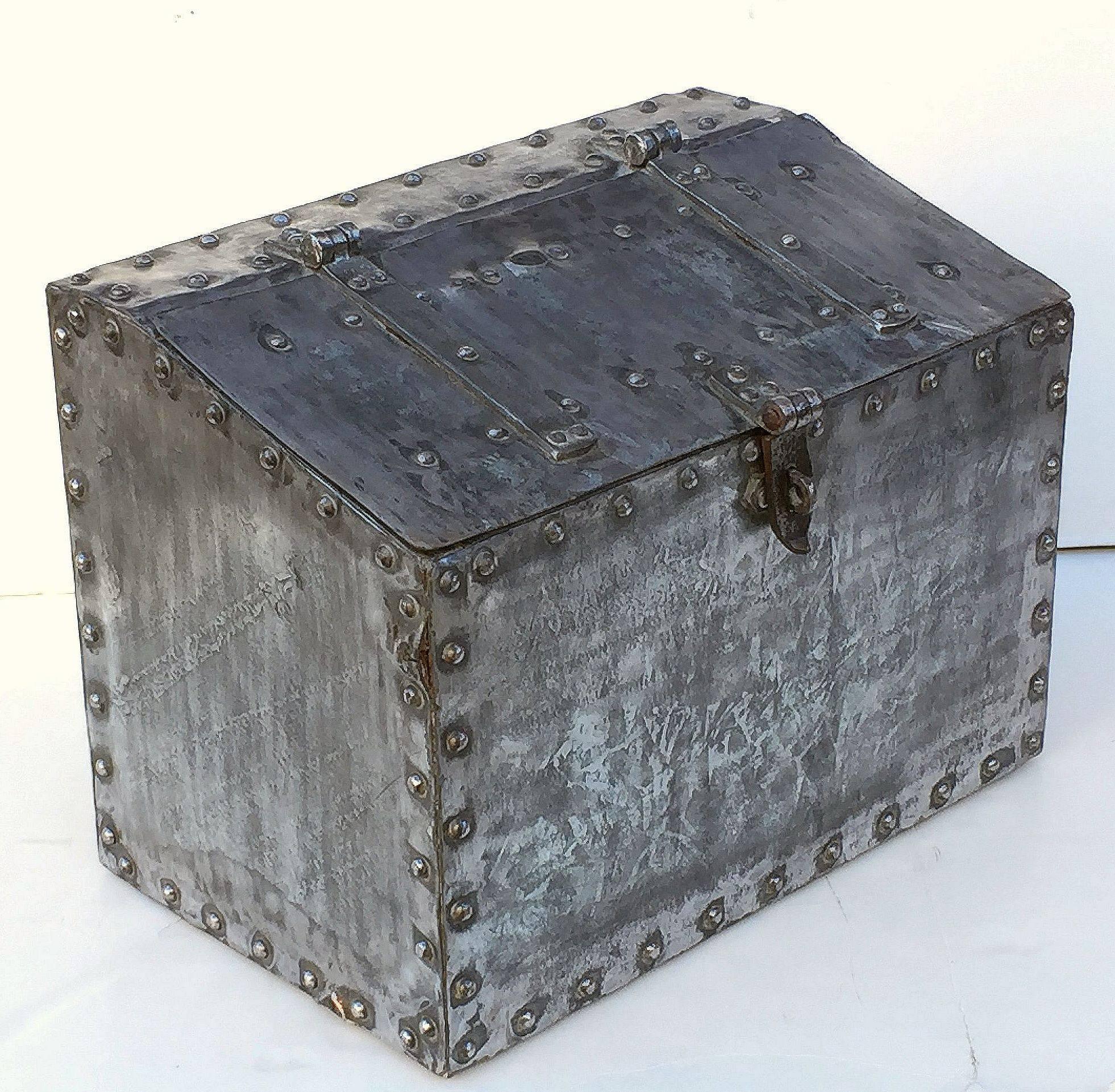 A handsome large English trunk or grain storage bin of polished iron from the 19th century, featuring a canted front with hinged lid and bolted cladding around the whole.
