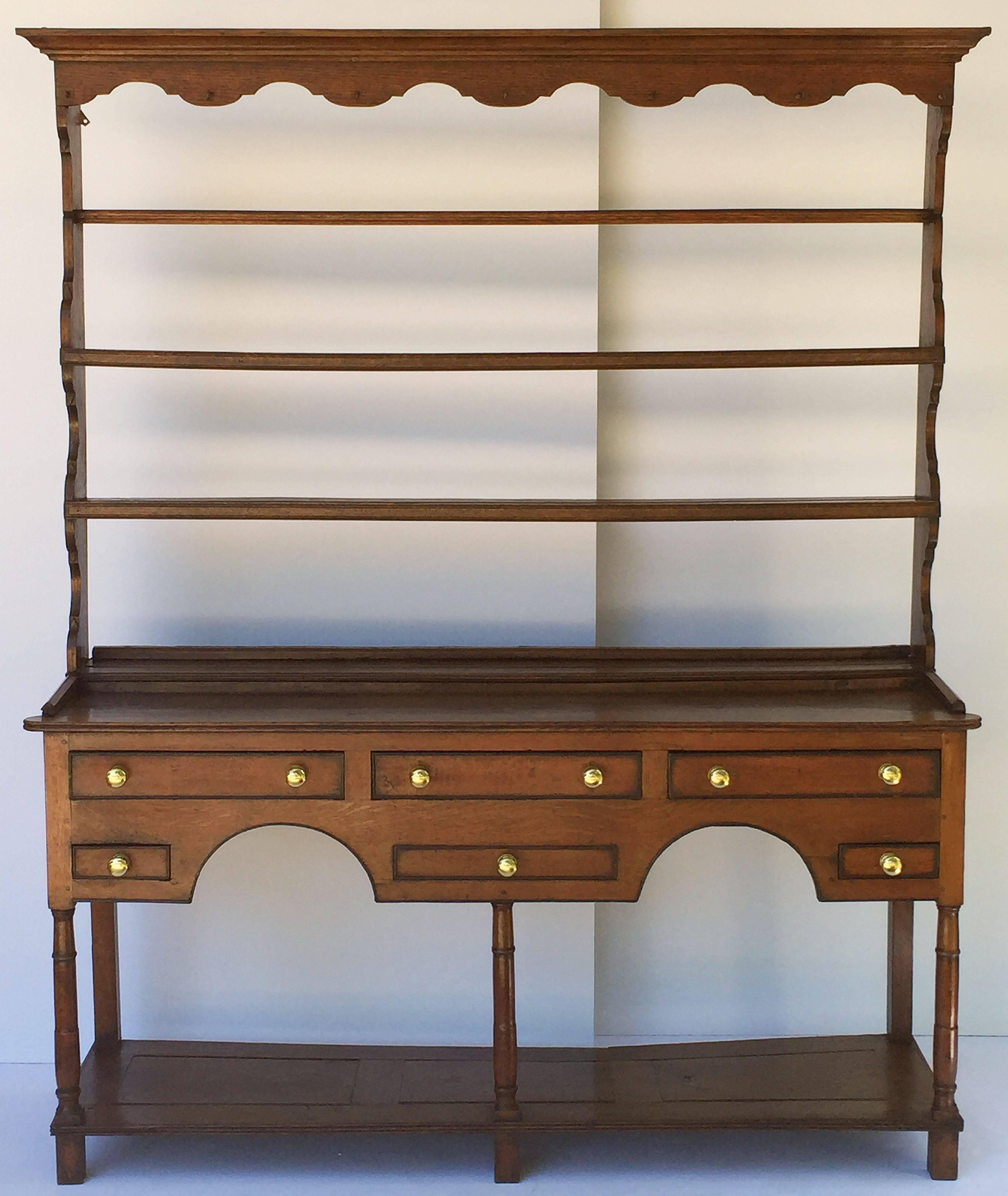 A handsome Welsh country pot board dresser of oak featuring a moulded crown top with ogee apron, over a plate rack with grooved plate rail and ogee sides.

Mounted to a dresser base frieze with five working drawers and one faux drawers, each