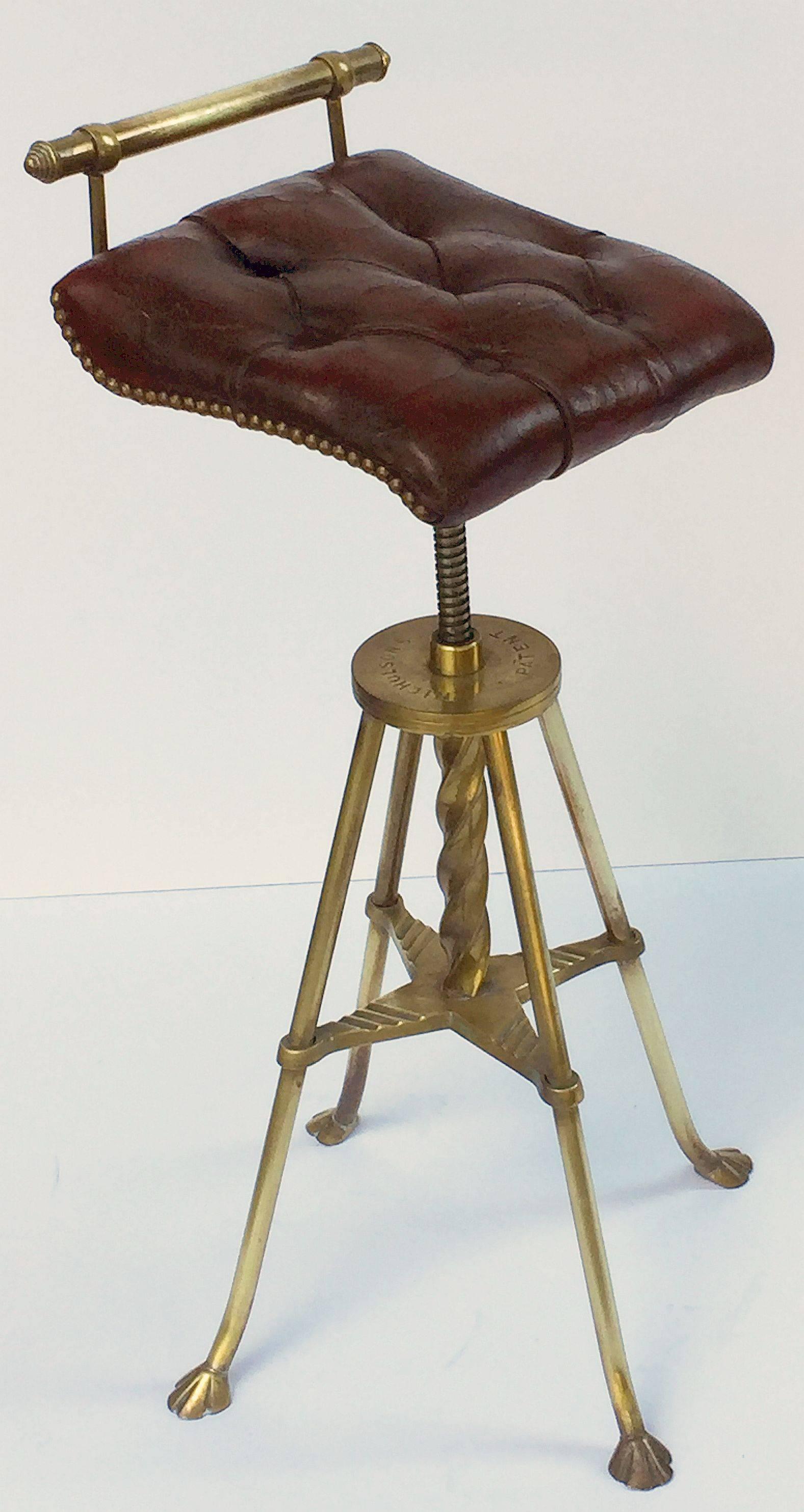 A fine English harpist's stool of brass with rotating or swivel seat with original button leather upholstery, mounted to four-legged stool base with barley-twist and crossbar brace. Adjusts to various heights for comfort of the musician.

Marked: