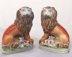 Pareja de leones ingleses de Staffordshire del siglo XIX con corderos