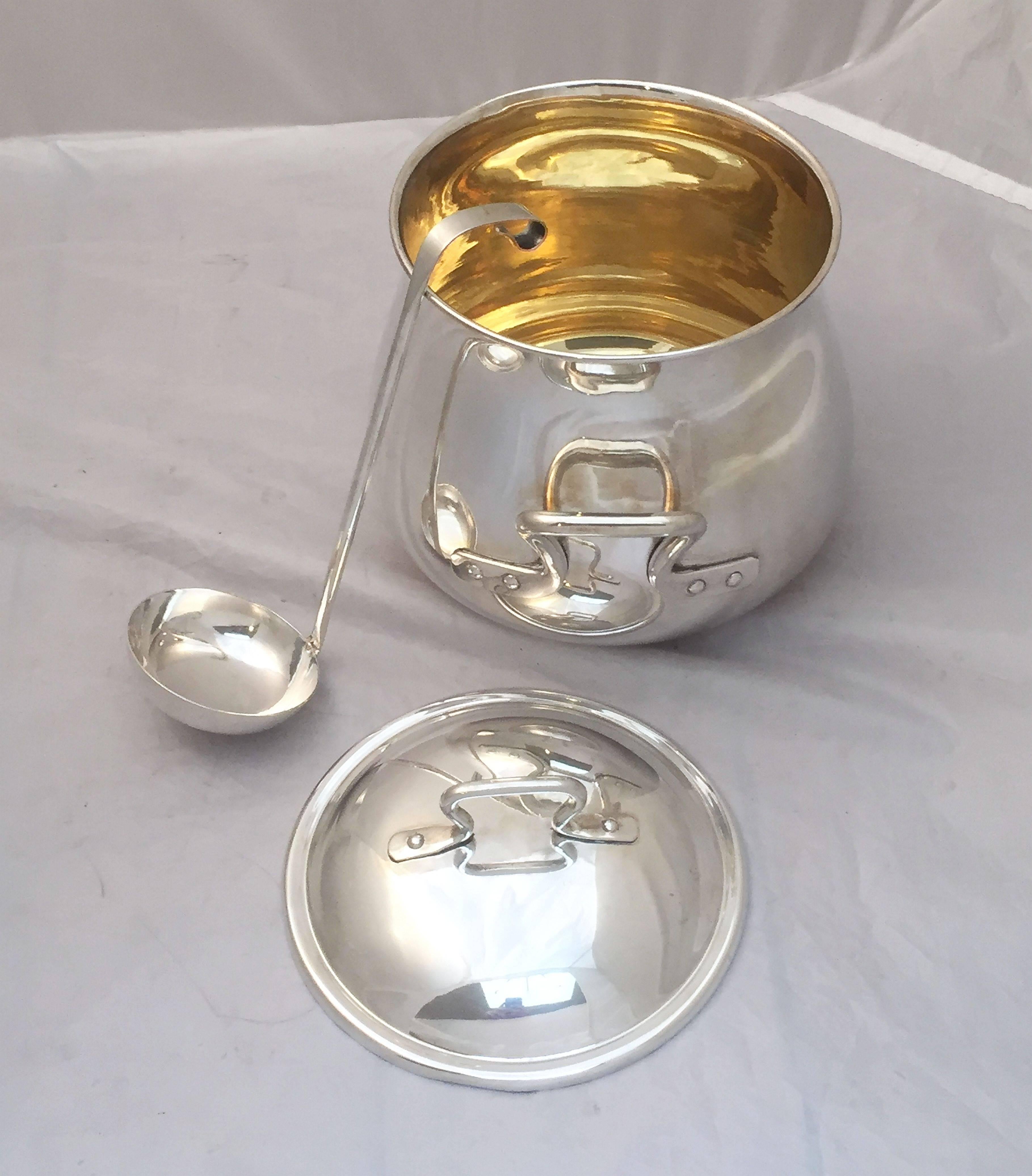 A fine French silver serving bowl or tureen with lid and ladle, featuring a bowl with two opposing handles and gold-washed interior, circular lid or top with handle, and stylish ladle.

Marked 800 silver on bowl base.