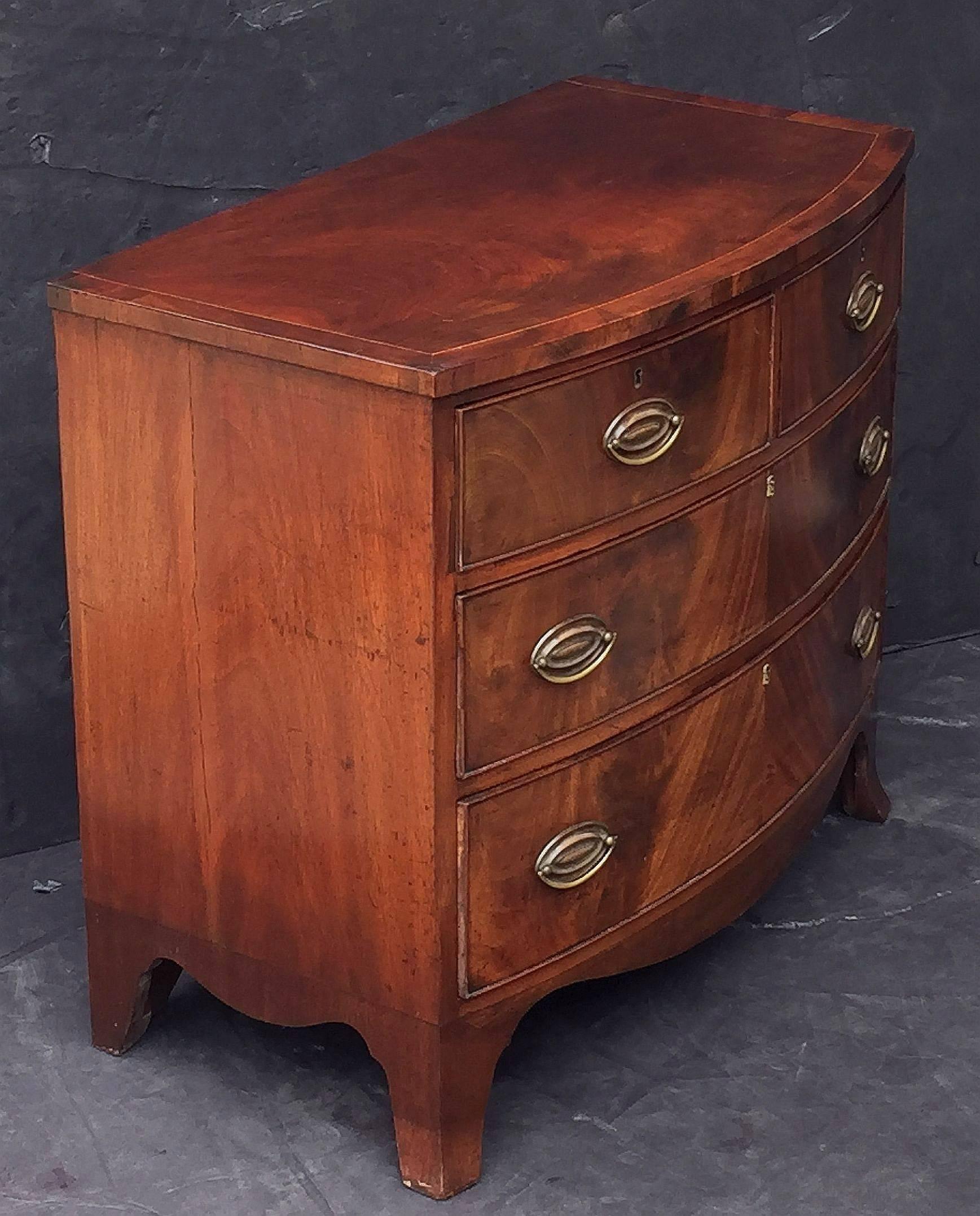 Brass English Bow Front Chest of Inlaid Flame-Cut Mahogany