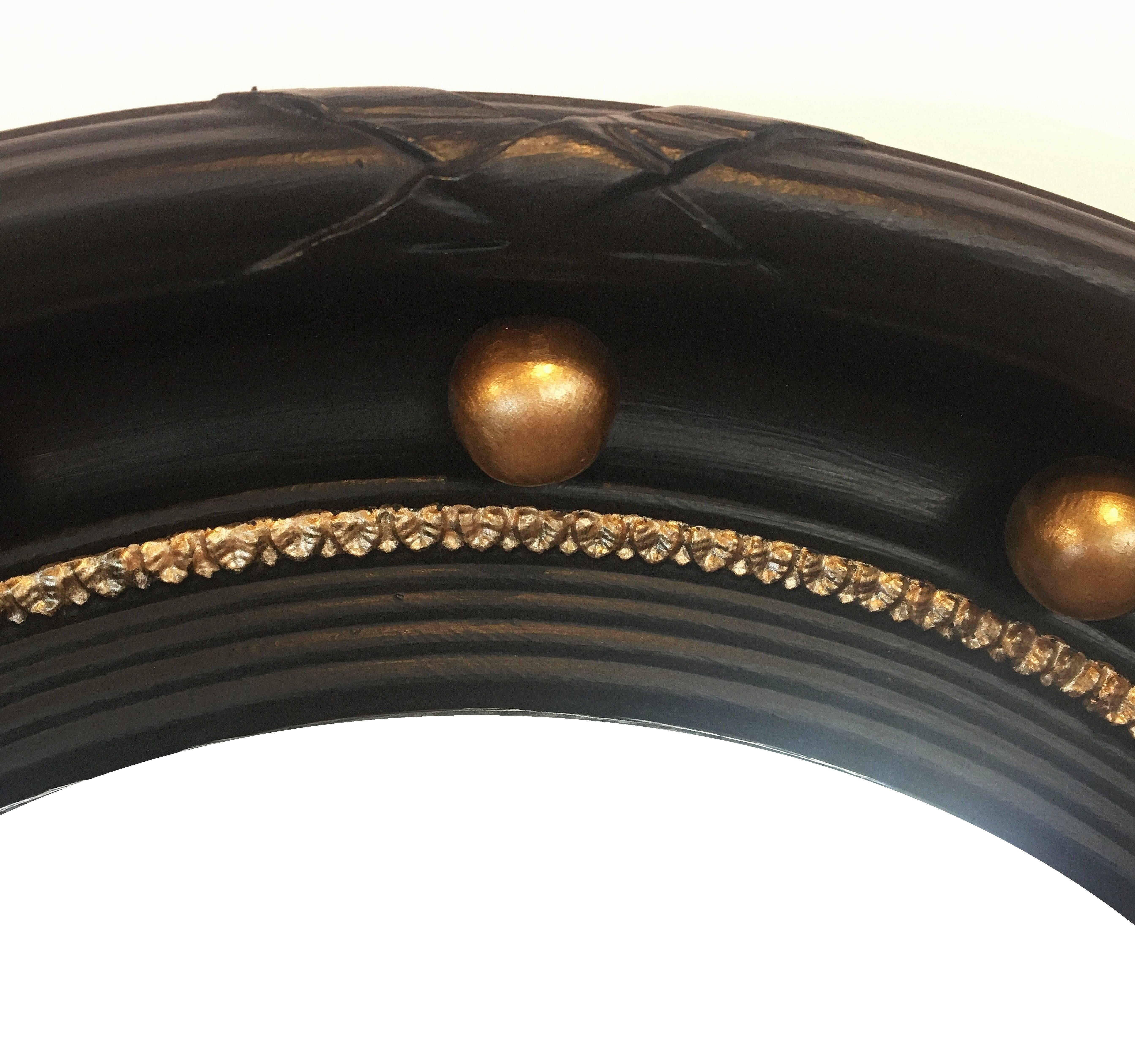 A fine English round convex mirror featuring a Regency design of a moulded, ebonised frame with gilt balls around the circumference.

Diameter is 17 1/4 inches