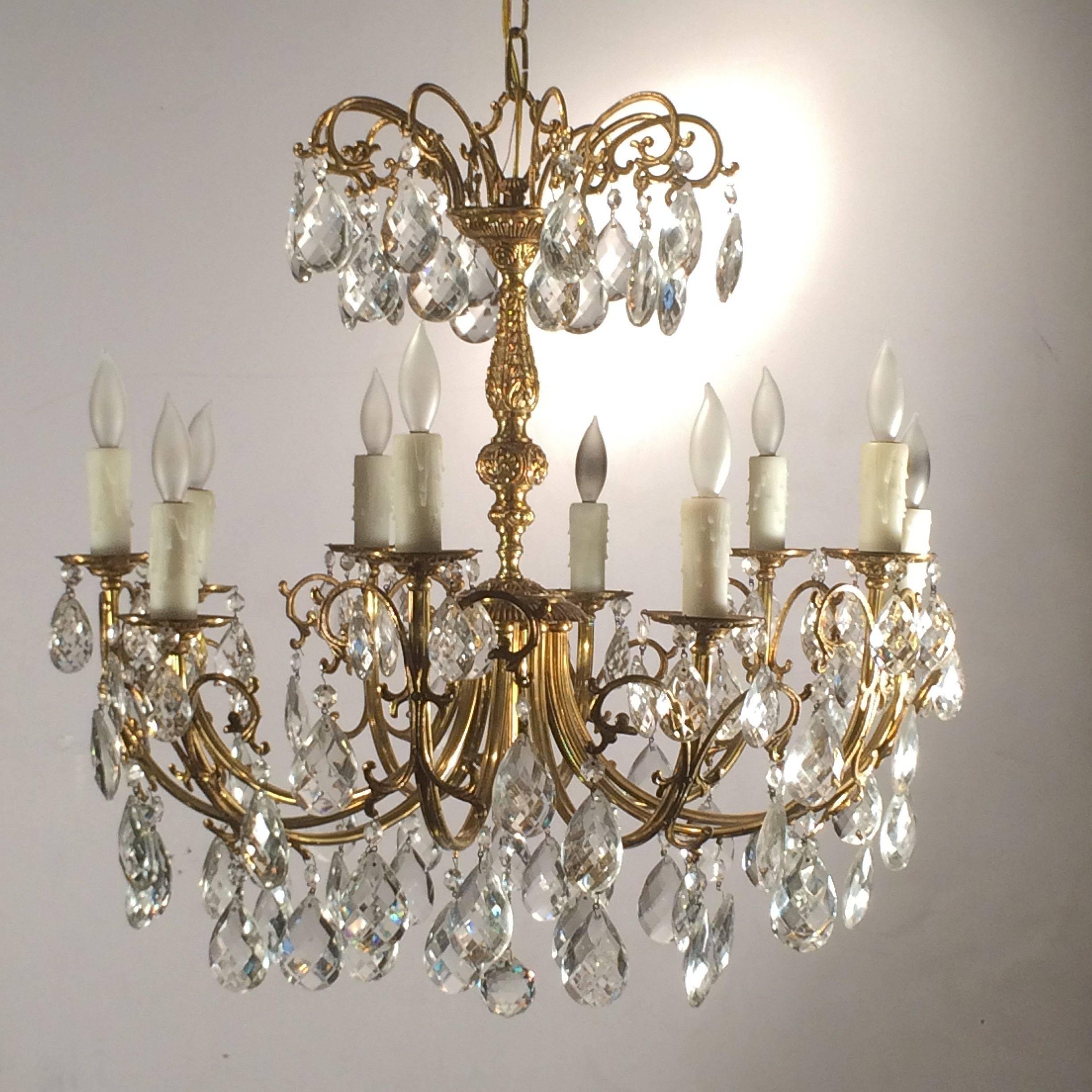 A fine Continental gilt metal and crystal drop ten-light chandelier or hanging fixture, featuring a Rococo body issuing ten gilt metal serpentine arms, holding faux candle holders terminating in lights, with crystal prism drops