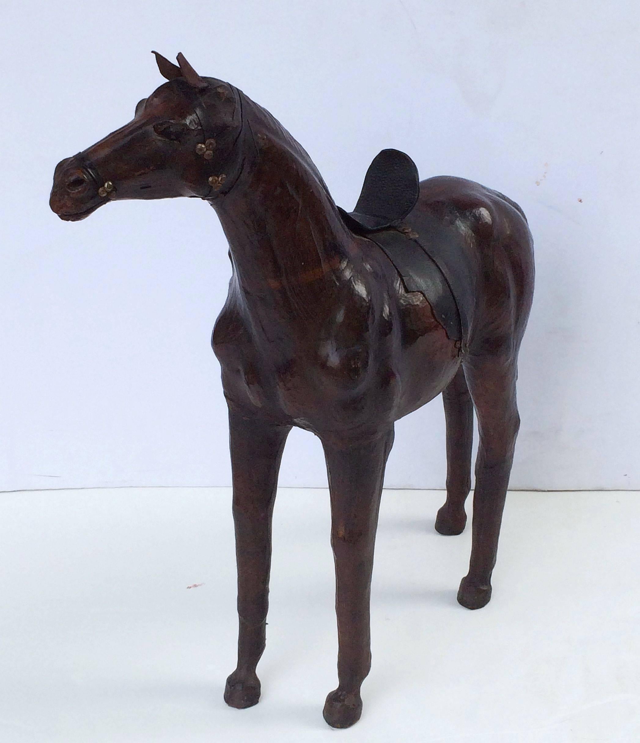 A French decorative horse model of leather with saddle, standing on four legs and featuring fine detail to the head and body.

