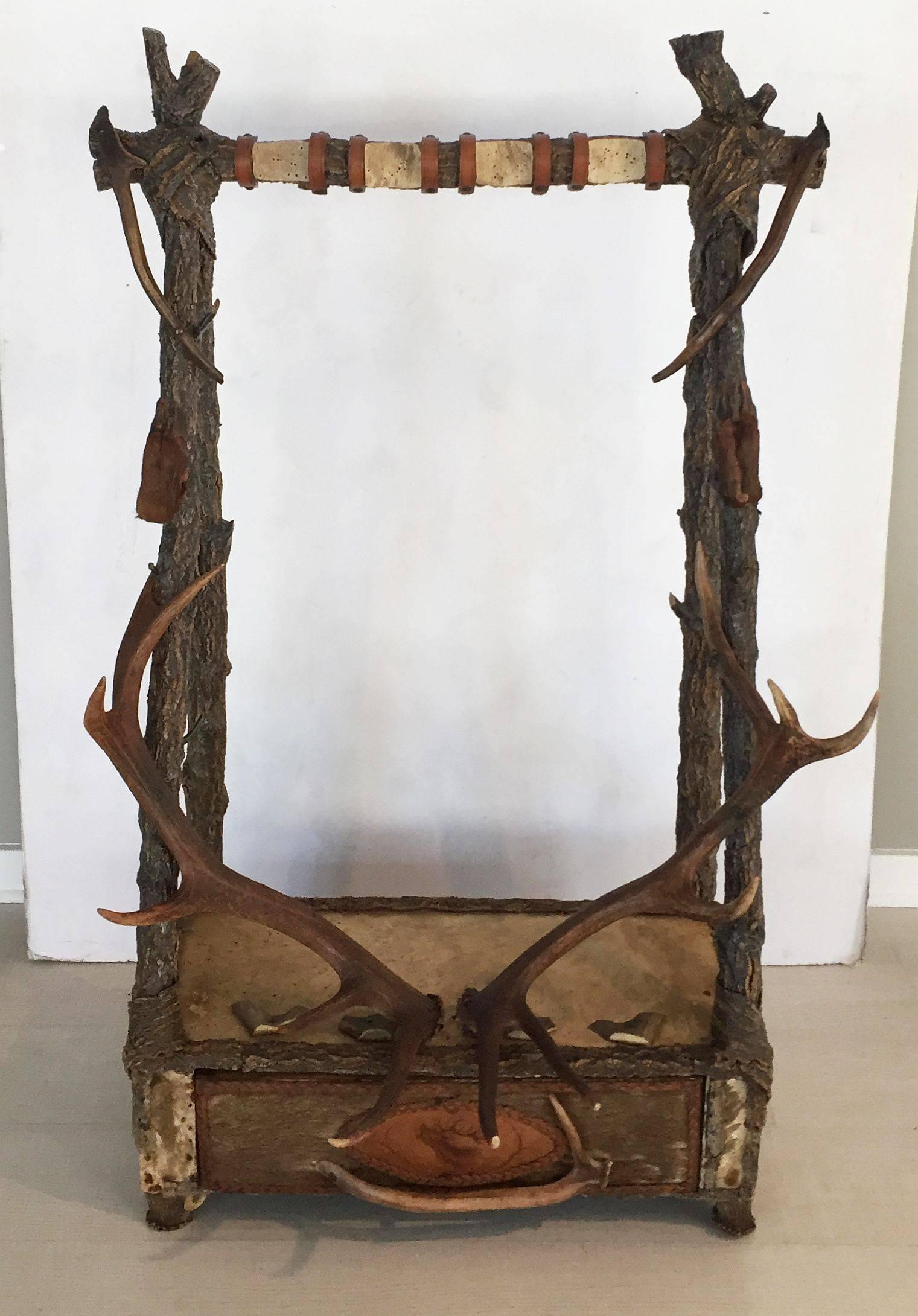 A fine Italian hunter's standing gun rack of antler horn, cork wood, hide and leather with storage drawer at base.