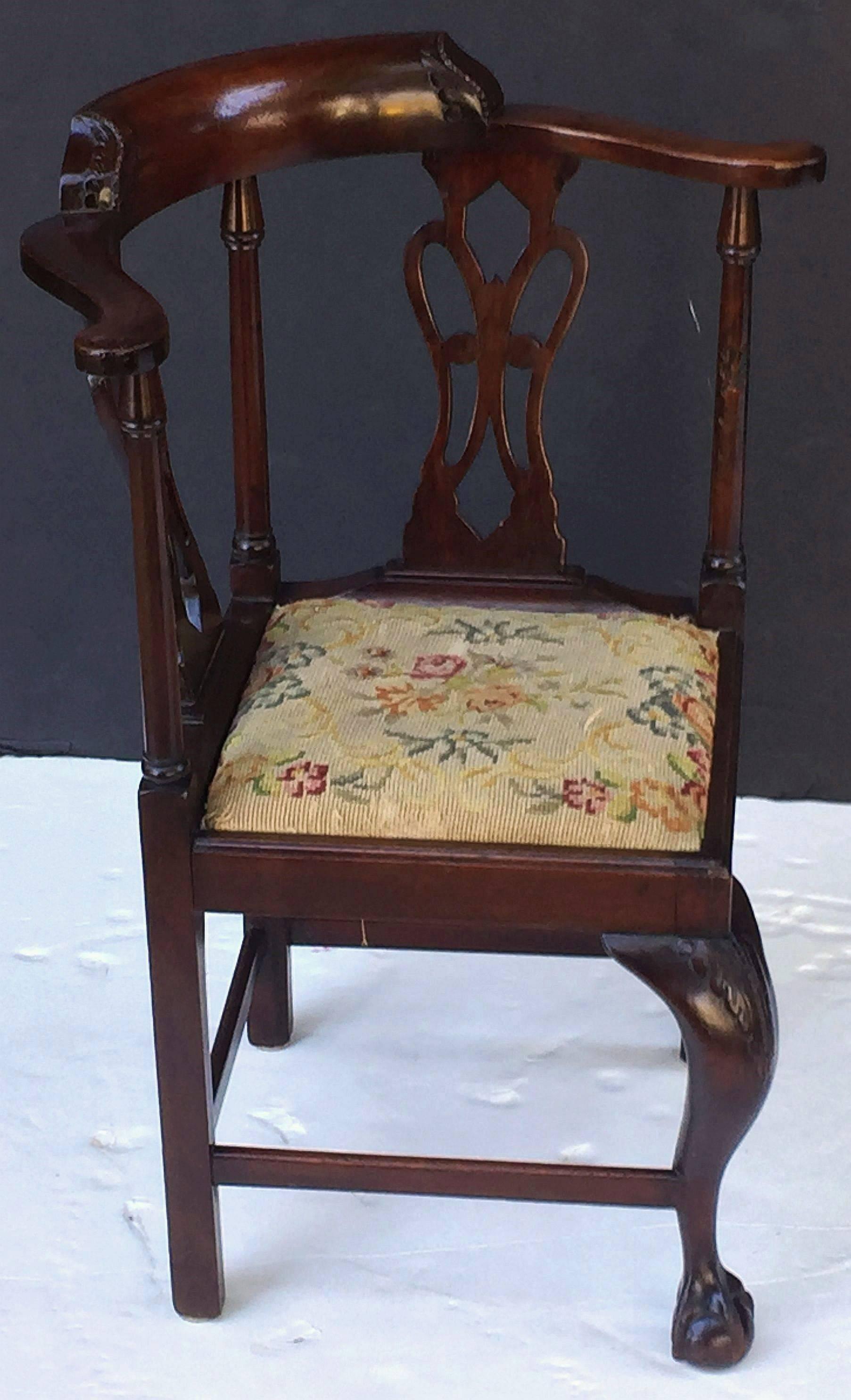 A fine English child's corner chair of mahogany with drop-in needlepoint seat, featuring the working design of an adult-sized chair but at a smaller scale. Handsomely moulded top rail with continuous serpentine arm mounted to a Classic square