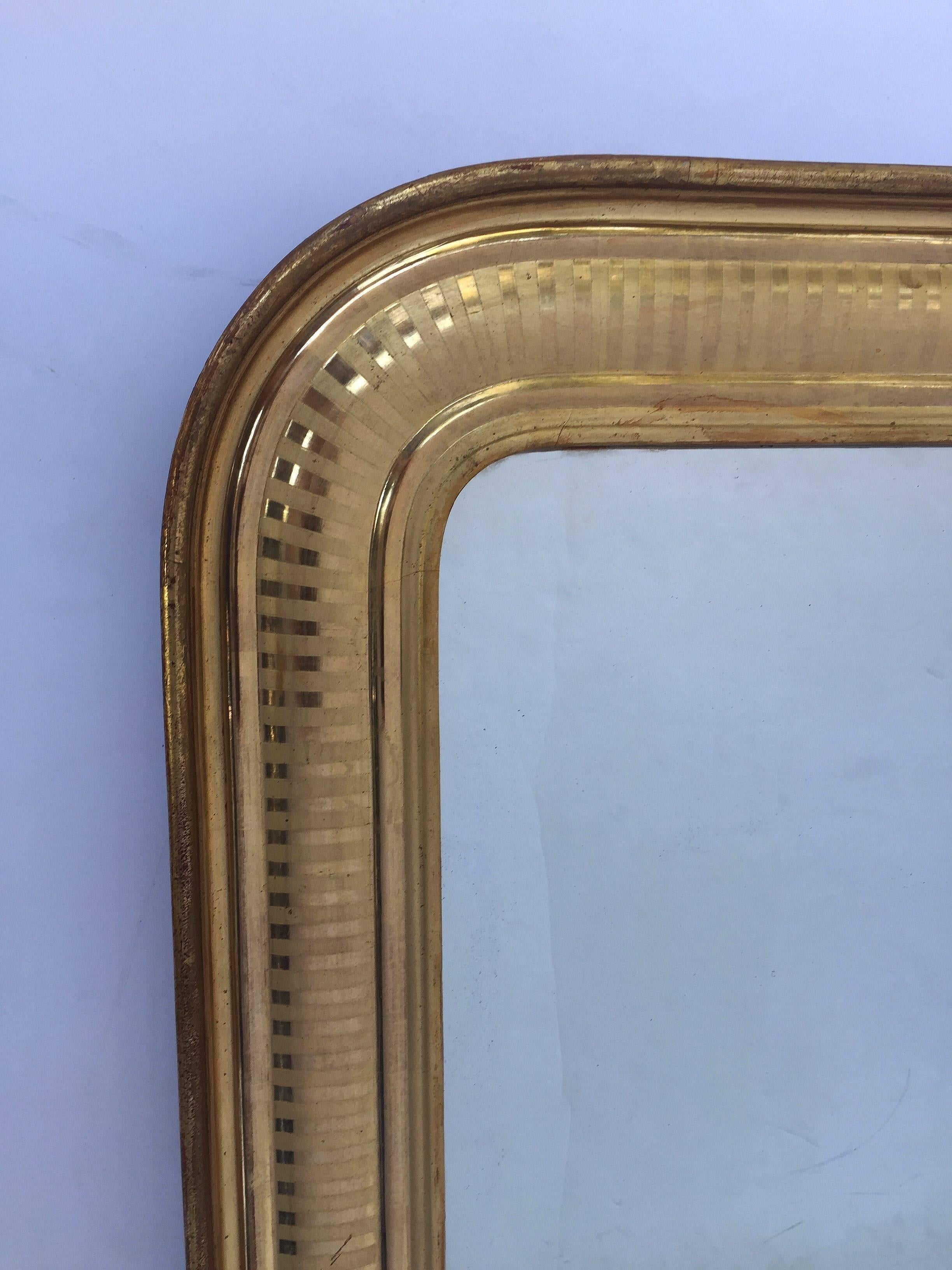 A handsome large Louis Philippe gilt wall mirror featuring a moulded surround and an etched band design showing through gold-leaf.

Dimensions: H 34 1/4