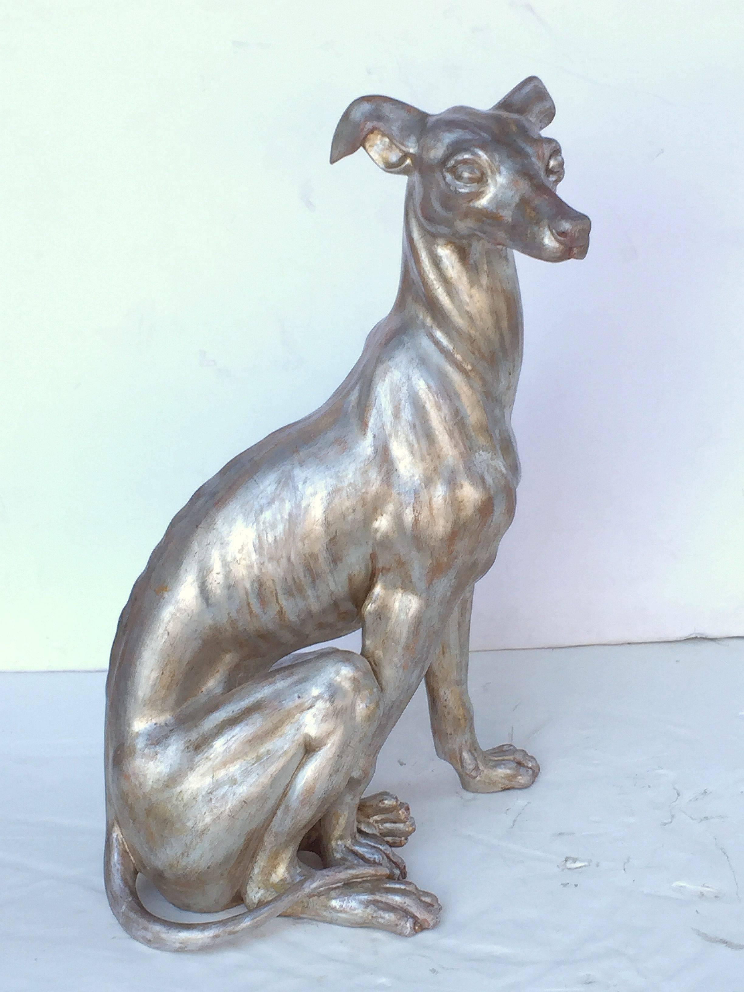 A handsome large Italian greyhound (or whippet) dog sculpture in a stylish seated pose, of carved wood with silver-leaf overlay.

Dimensions are

H  36 inches
W 23 inches
D 15 inches