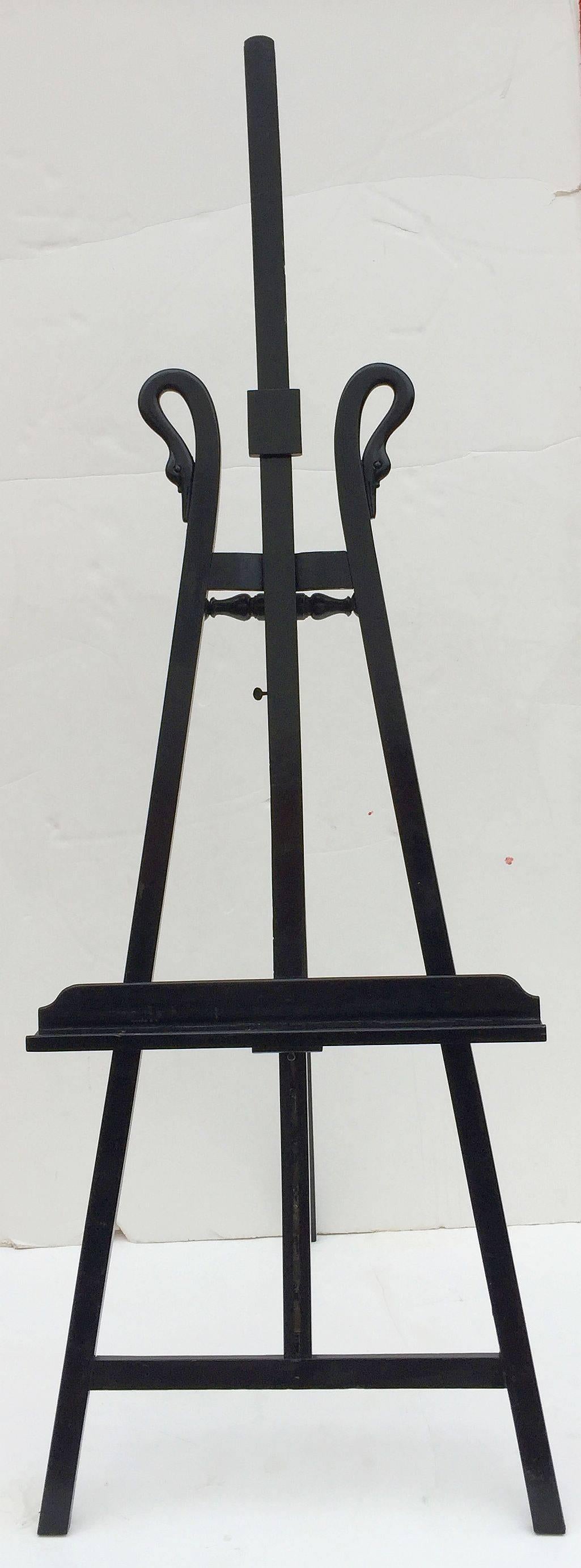 A handsome large French display easel of ebonized wood, featuring a decorative double swan neck design, adjustable canvas holder and tray, and adjustable support rail of wood and brass.

Measures: H 84