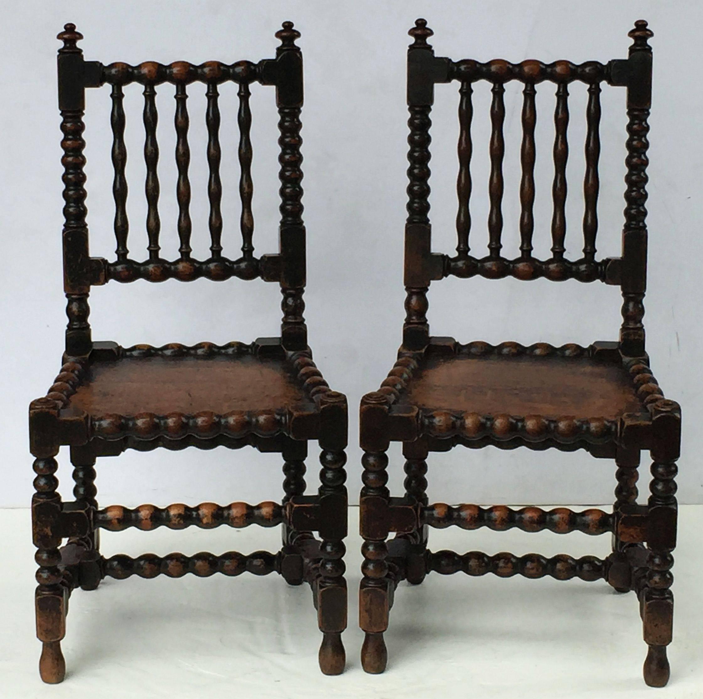 A fine pair of English bobbin turned chairs of oak from the Georgian period, each chair featuring a handsome patina, solid seat and turned back and legs.

Two chairs available, priced individually - $2495 each chair.