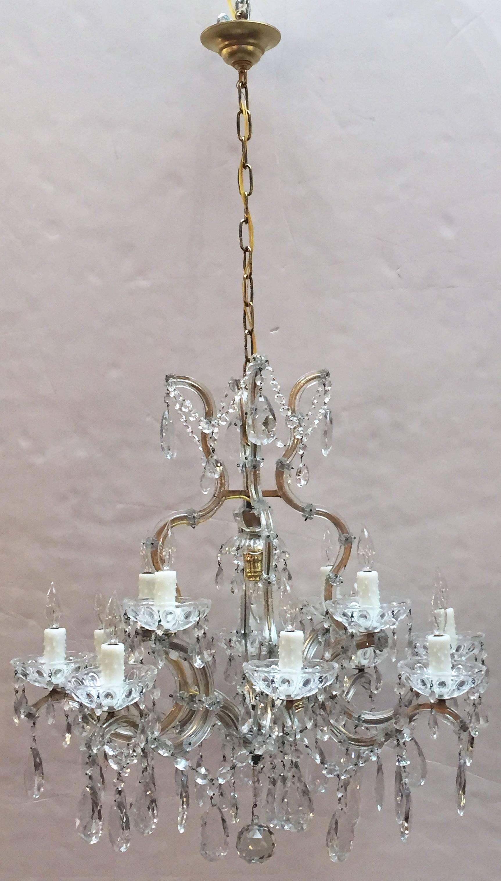 A fine large Maria Theresa seventeen-light chandelier (or hanging fixture) of crystal, glass and gilt metal featuring serpentine arms, each candle light with dangling pendants and decorative bobeche.

Measures: 29 inches diameter

U.S.-wired and