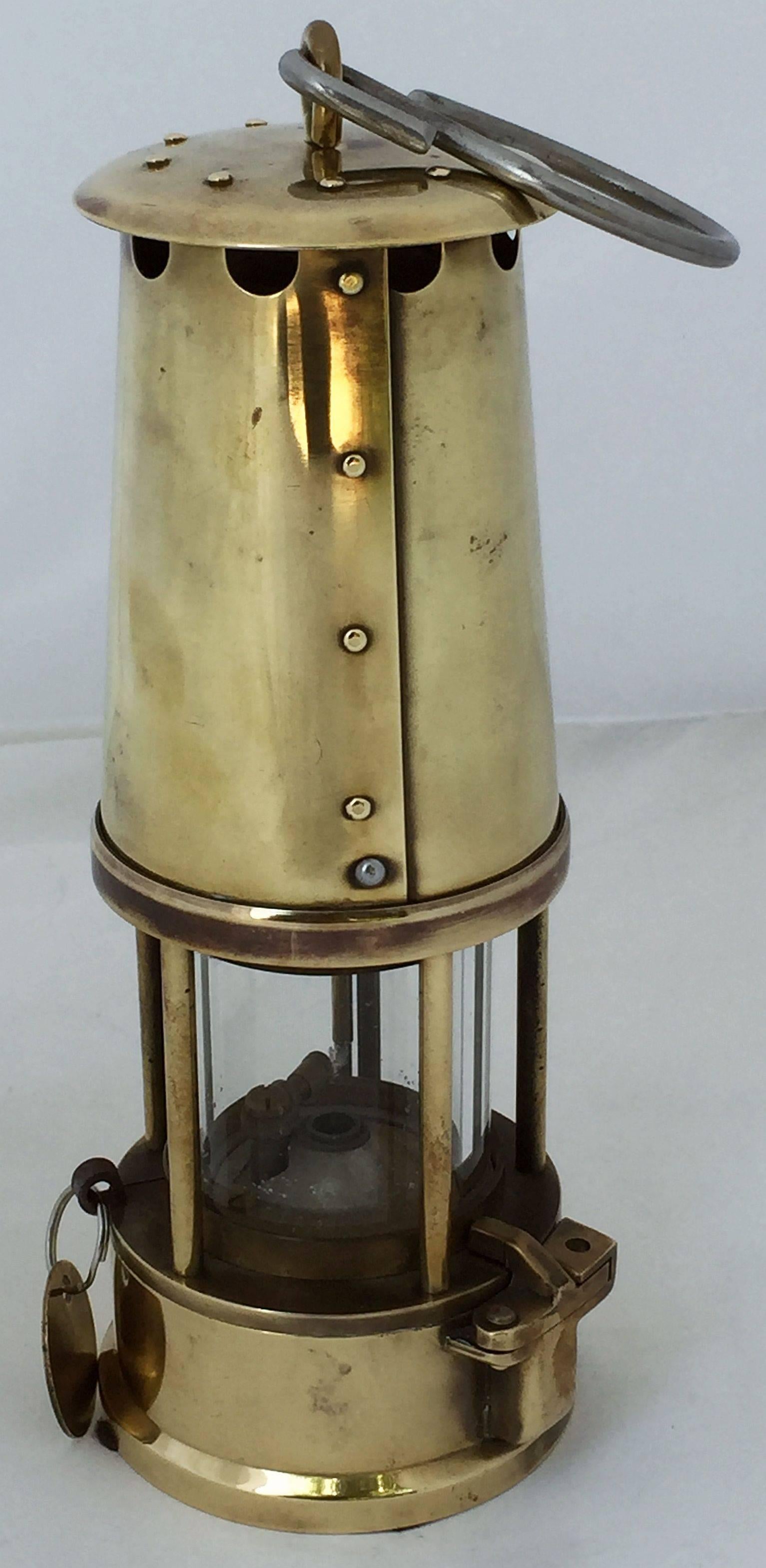 An English miner's lamp or safety lantern of brass in working order.
With maker's label and key with tag: 

The Protector Lamp & Lighting Co. Ltd. - Type 6, M & Q, Safety Lamps, Approval No. B/28, Makers, Eccles (Manchester).