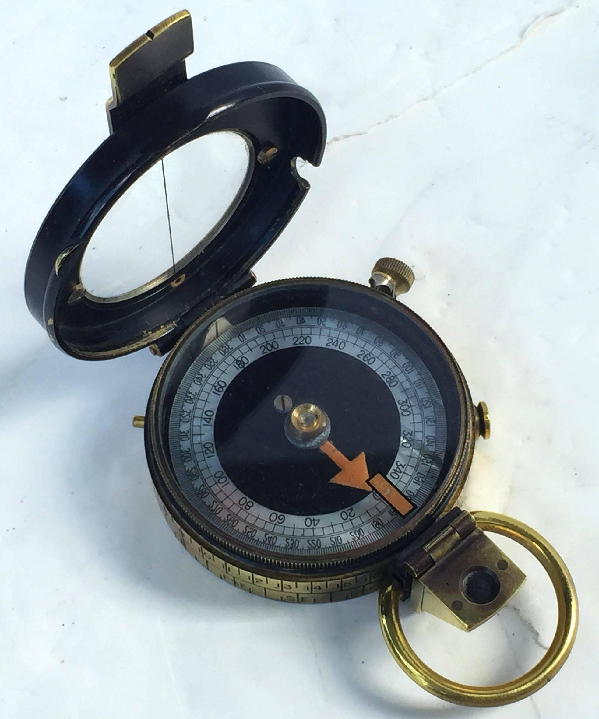 A working British military marching or sighting compass of heavy brass in original leather case from World War I.
Known as a Verner's pattern VIII prismatic compass, with radium and mother-of-pearl dial.

Back with arrow mark denoting use by the