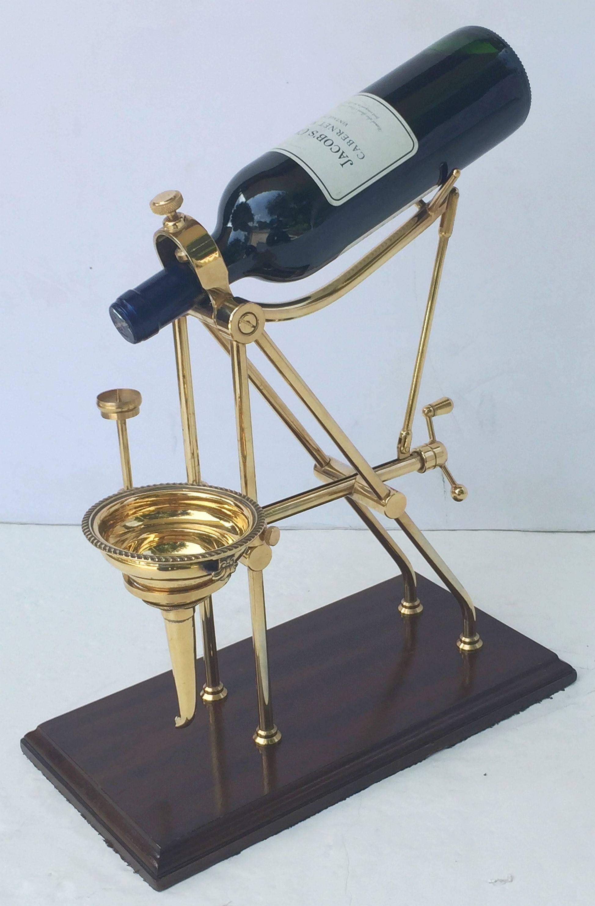 A handsome English vintage port wine decanting cradle which allows for precise decanting of your favorite aged wines. The brass cradle has an adjustable neck which accommodates a variety of bottle lengths and the precisely engineered hand crank