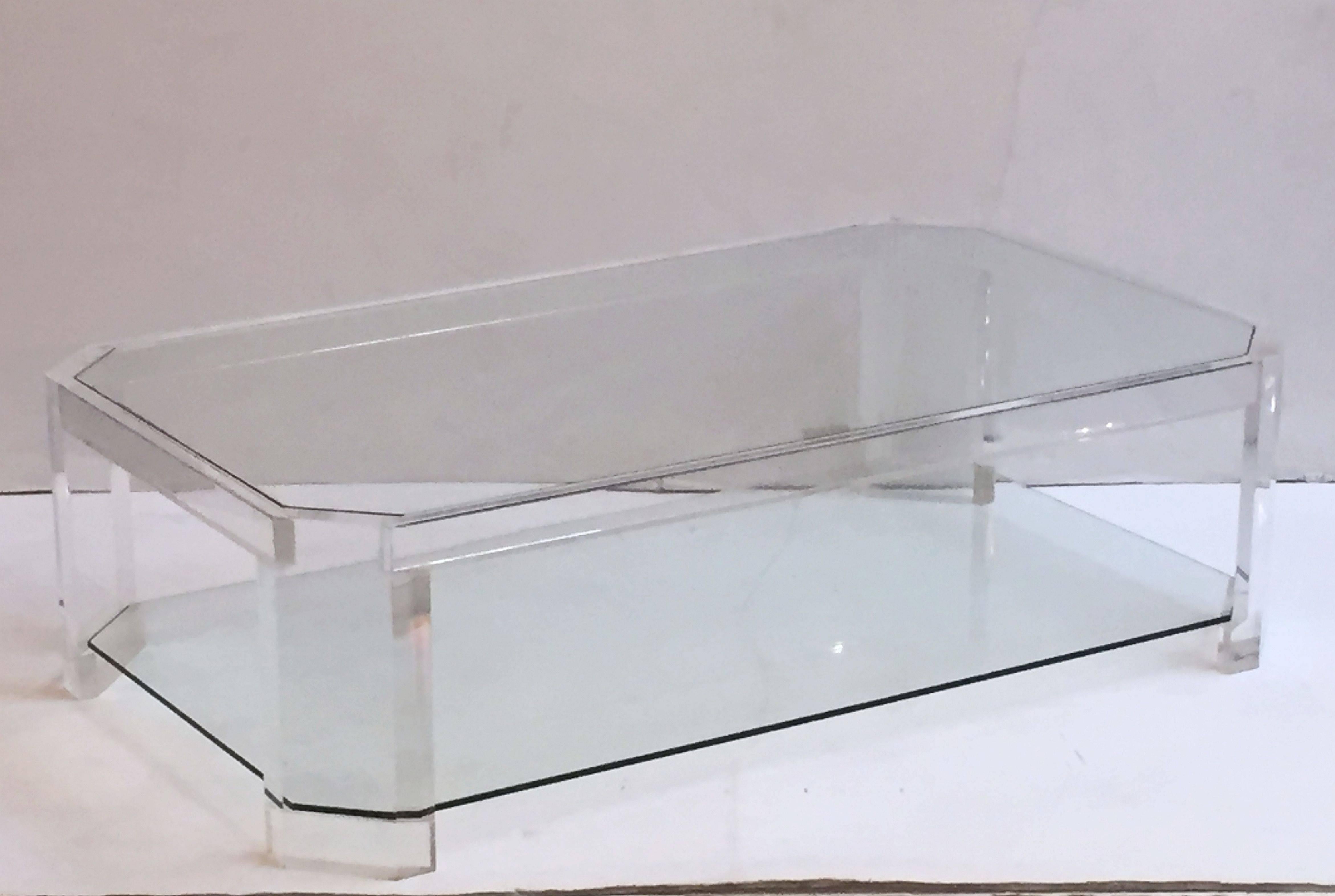 A fine large French rectangular coffee or low cocktail table of Lucite with two inset tiers of glass, with canted corners.

Attributed to David Lange, designer.