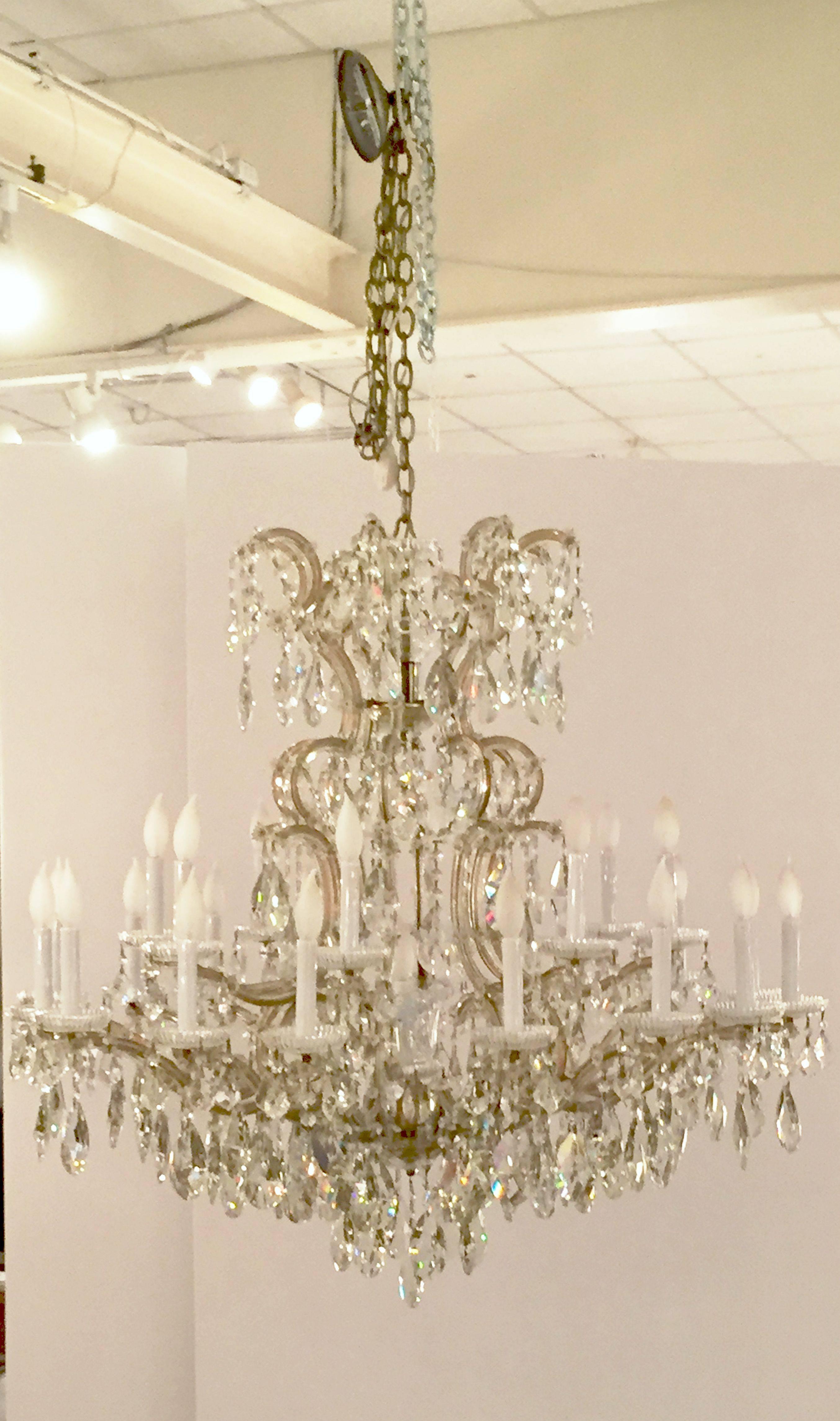 A lovely extra large Maria Theresa style twenty-four-light chandelier (or hanging fixture) of crystal, glass and gilt metal featuring 16 serpentine arms - the arms alternating between one light and two lights to each arm, each candle light with