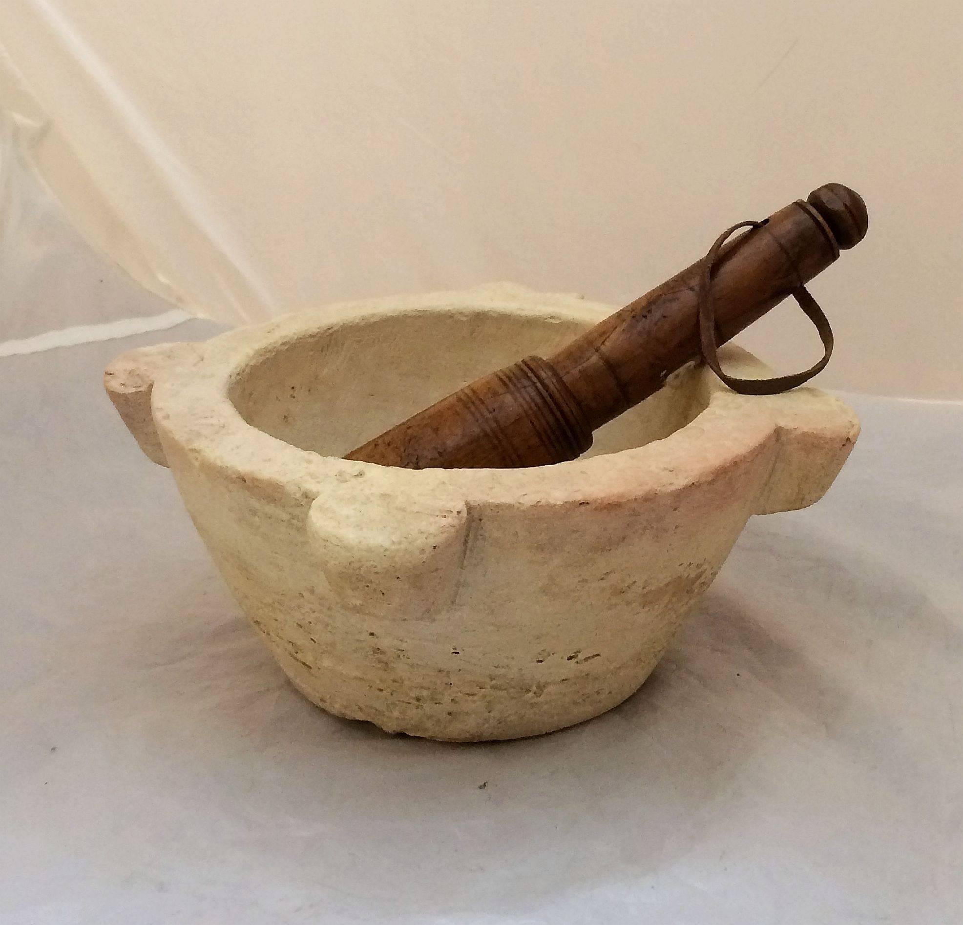 A handsome French mortar and pestle from the 19th century, featuring a turned pestle of fruitwood with leather string handle and mortar bowl of cut stone.

A fine piece of kitchenalia and functional for grinding herbs, etc.