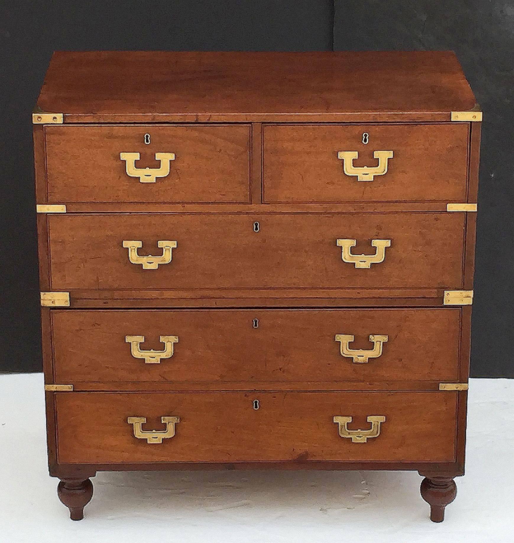A fine English military officer’s Campaign Ware chest, featuring a handsome teak exterior, showing two short drawers over three long drawers. The brass-bound chest, in two parts, accented with brass hardware and porter’s handles, resting on shaped