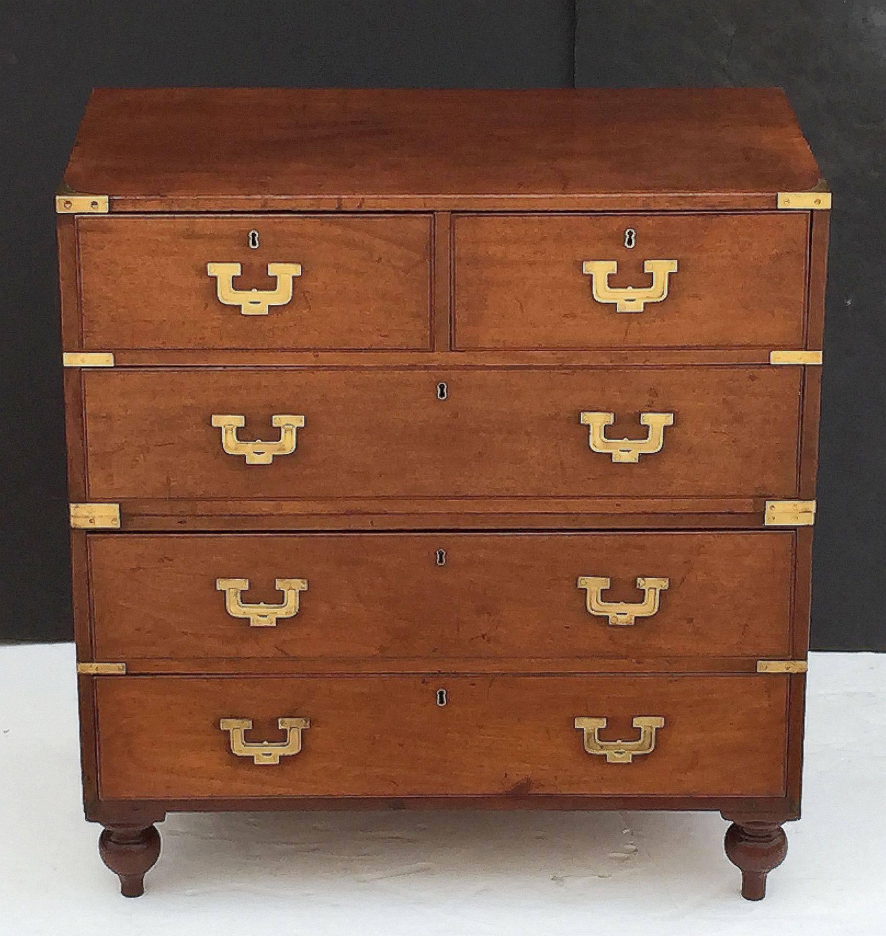 A fine English military officer’s Campaign Ware chest, featuring a handsome teak exterior, showing two short drawers over three long drawers. The brass-bound chest, in two parts, accented with brass hardware and porter’s handles, resting on shaped