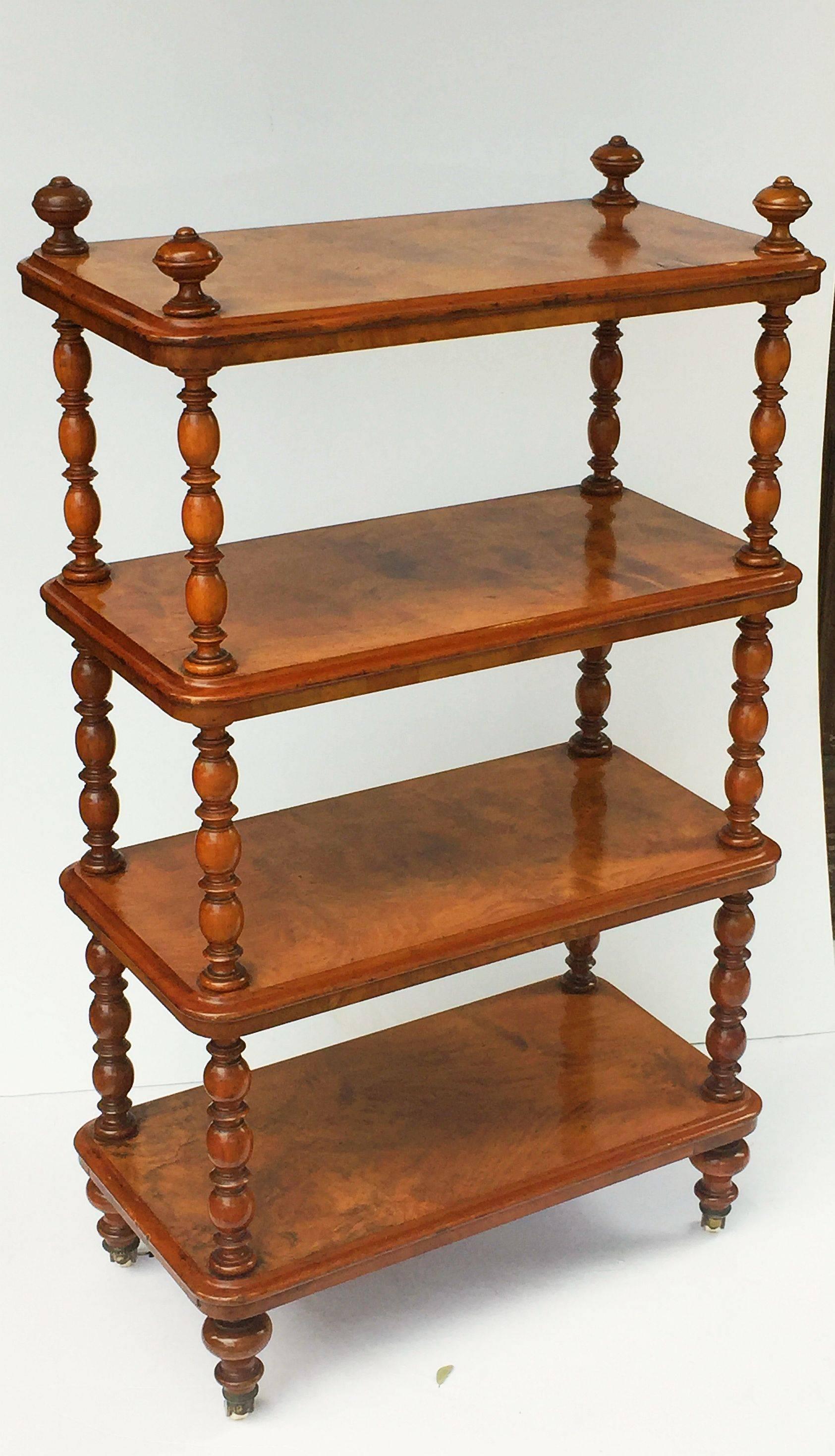 A fine English etagere (whatnot) or set of standing shelves of burled walnut, featuring four rectangular shelves of figured walnut, with moulded edges, mounted to four barley twist supports of turned walnut, with turned finials at top, and turned