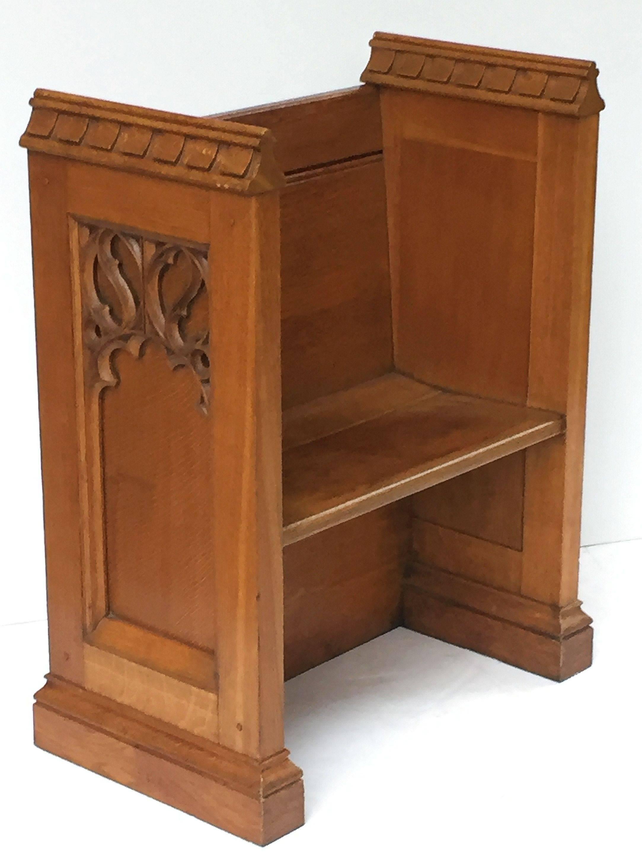 A handsome large English ecclesiastical prayer bench (seat) or pew of oak in the Gothic style, featuring two sides panelled with carved Gothic designs of quatrefoils on one end and Tudor roses on the other, a bench seat and back, set upon a moulded