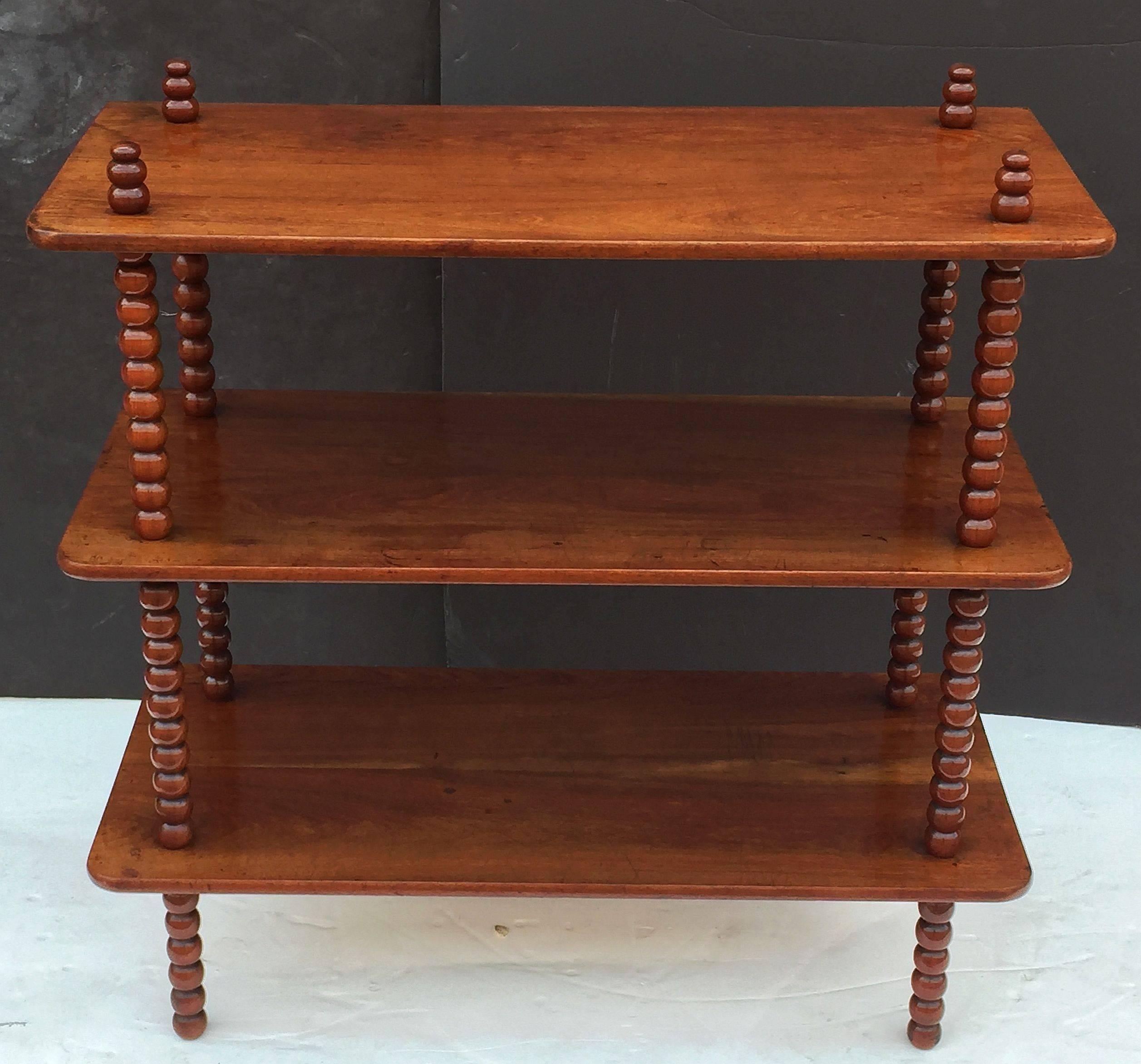 A fine English rectangular console or buffet with three tiers or shelves and four bobbin turned supports of mahogany.