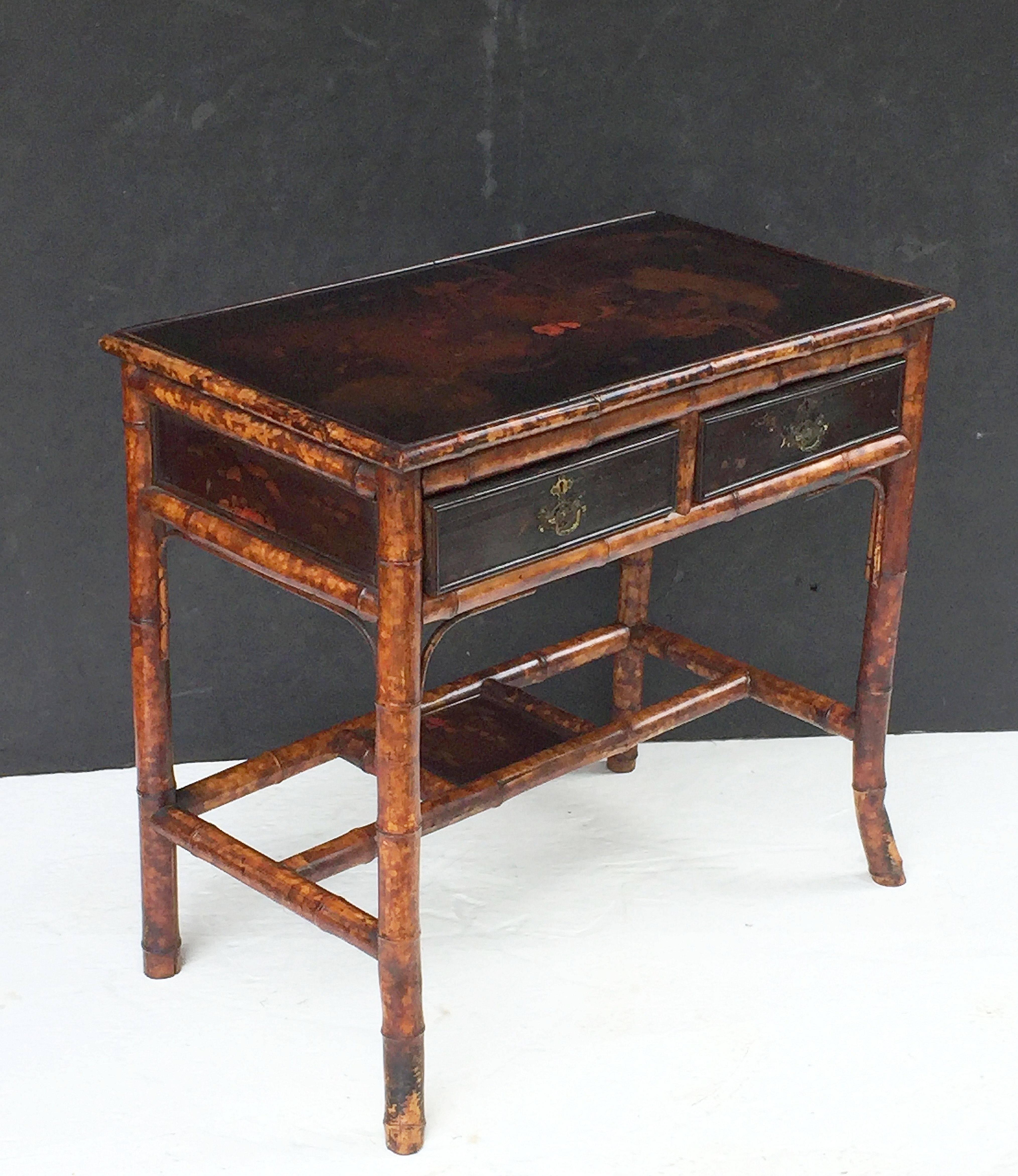 A fine English bamboo desk from the Aesthetic Movement era, circa 1870-1910, featuring a japanned lacquer top over a frieze of two drawers, each drawer with lacquer paneled front and brass hardware, and pressed paper to back.
Set upon a bamboo