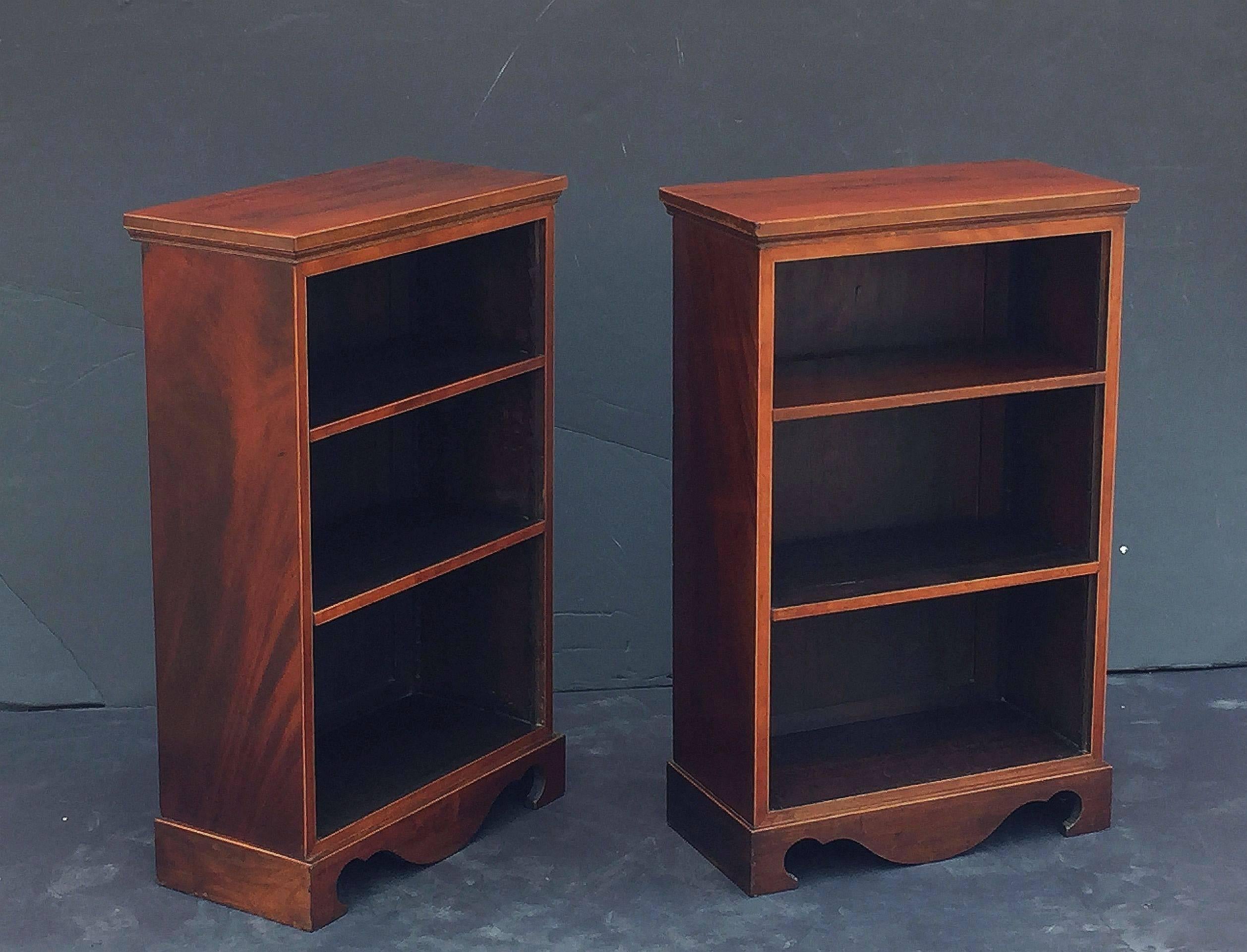 A fine pair of Scottish open bookcases of mahogany, each bookcase featuring moulded tops of mahogany with accents of strung inlay, two adjustable shelves and raised plinth bases with serpentine apron.

Each bookcase measures H 37 in. x W 23 in. x