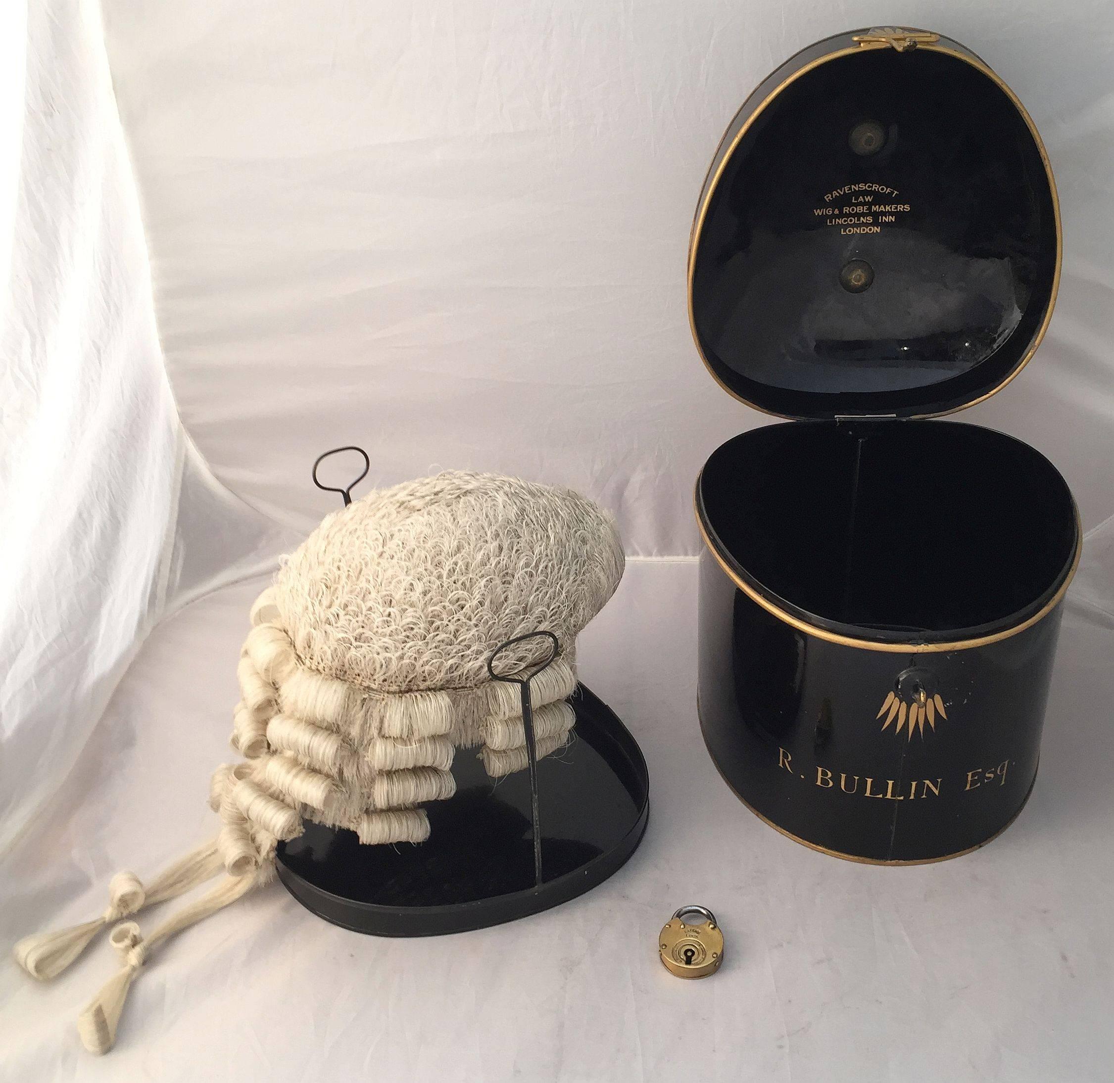 An English barrister’s wig of woven horse hair in original tole box with lock and key, circa 1850-1890, featuring a barrister’s wig with accompanying riser, in a fitted black tole box with gold accents and brass swan handle, the exterior marked 'R.