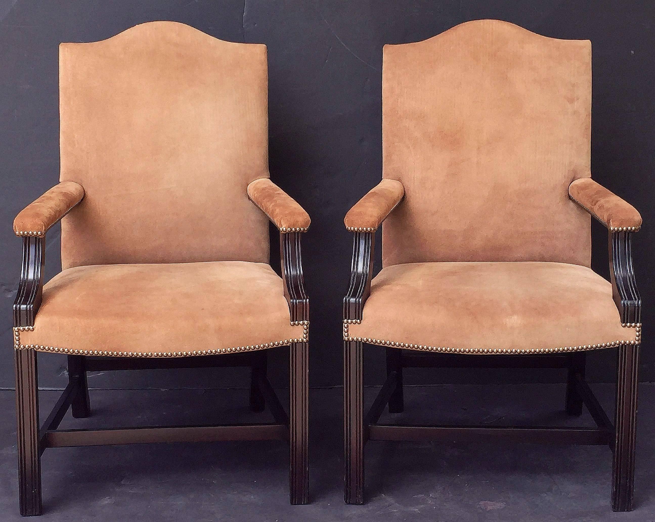 A fine pair of comfortable English library armchairs in the Georgian Gainsborough style, made by George Smith, 20th century, and featuring stylish arms.
Having handsome suede leather covers, stubs, backs, and seats with brass studded edges.
With