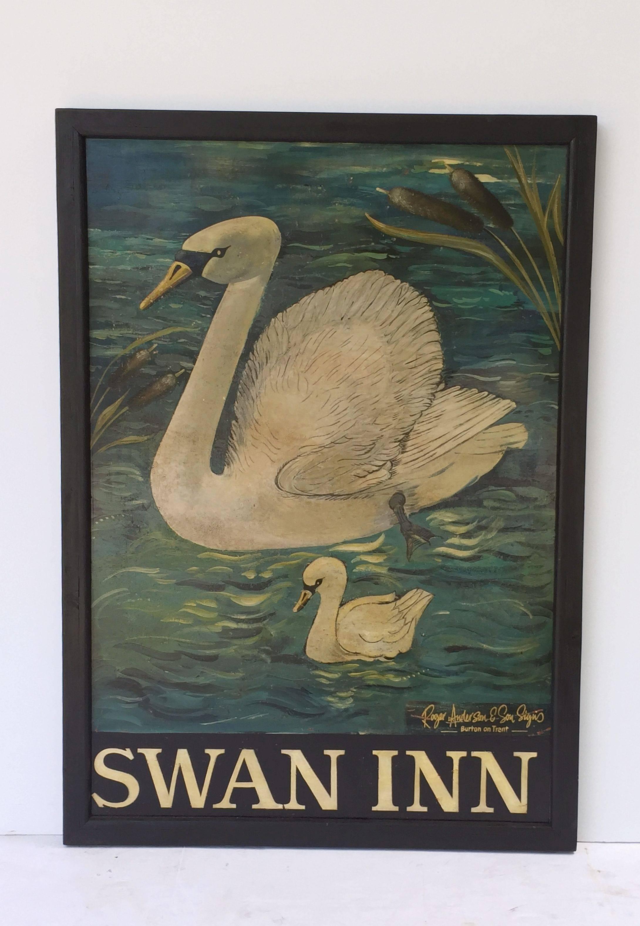 An authentic English pub sign (one-sided) featuring a painting of an adult swan with a child swan or cygnet, on the water with bulrushes or cat-tails in the background, entitled: Swan Inn

Signed at bottom: Roger Anderson & Son Signs,