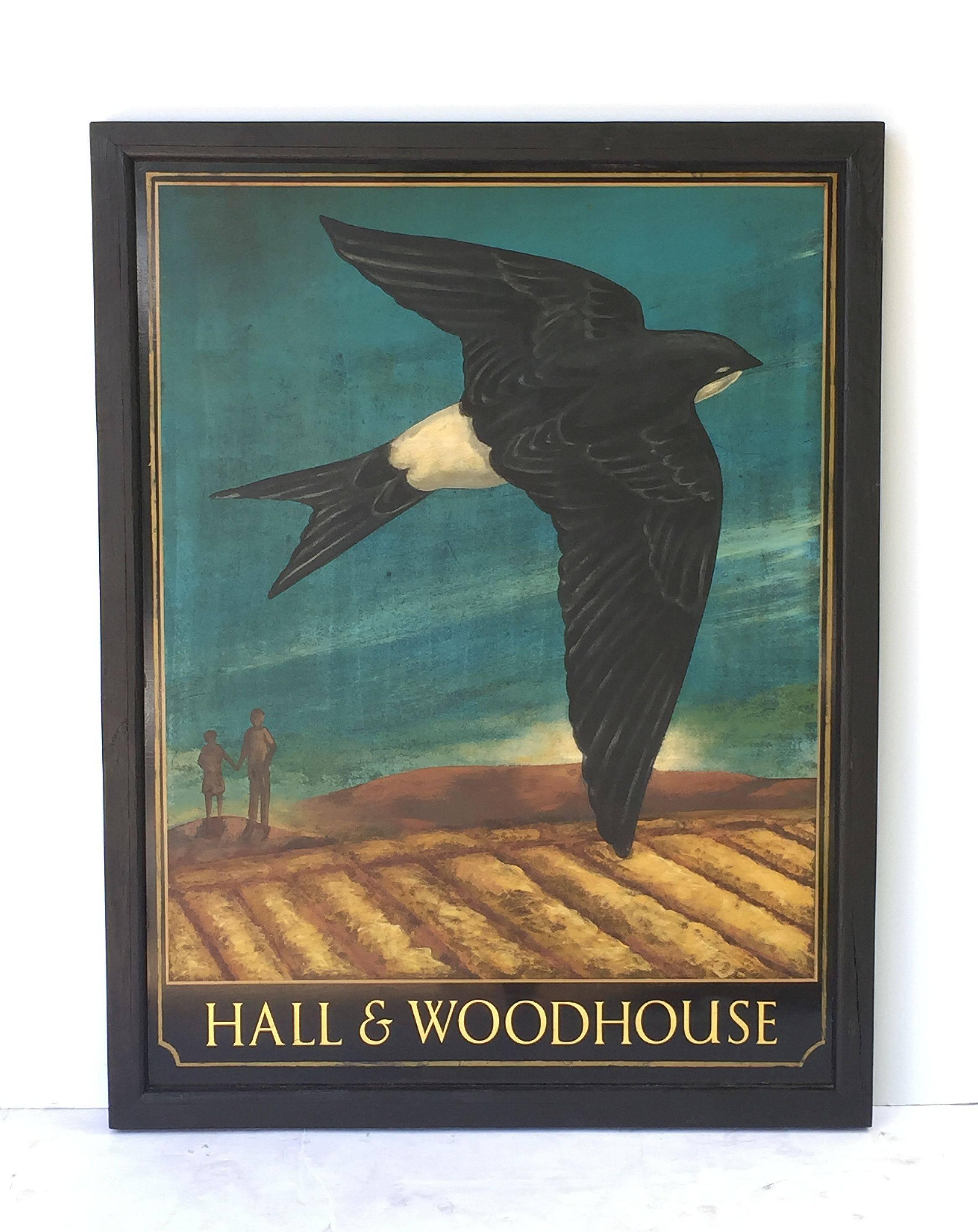 An authentic English pub sign (one-sided) featuring a painting of a swallow bird flying above a landscape with two figures in the background, entitled: Hall & Woodhouse

Hall and Woodhouse is a British regional brewery founded in 1777 by Charles