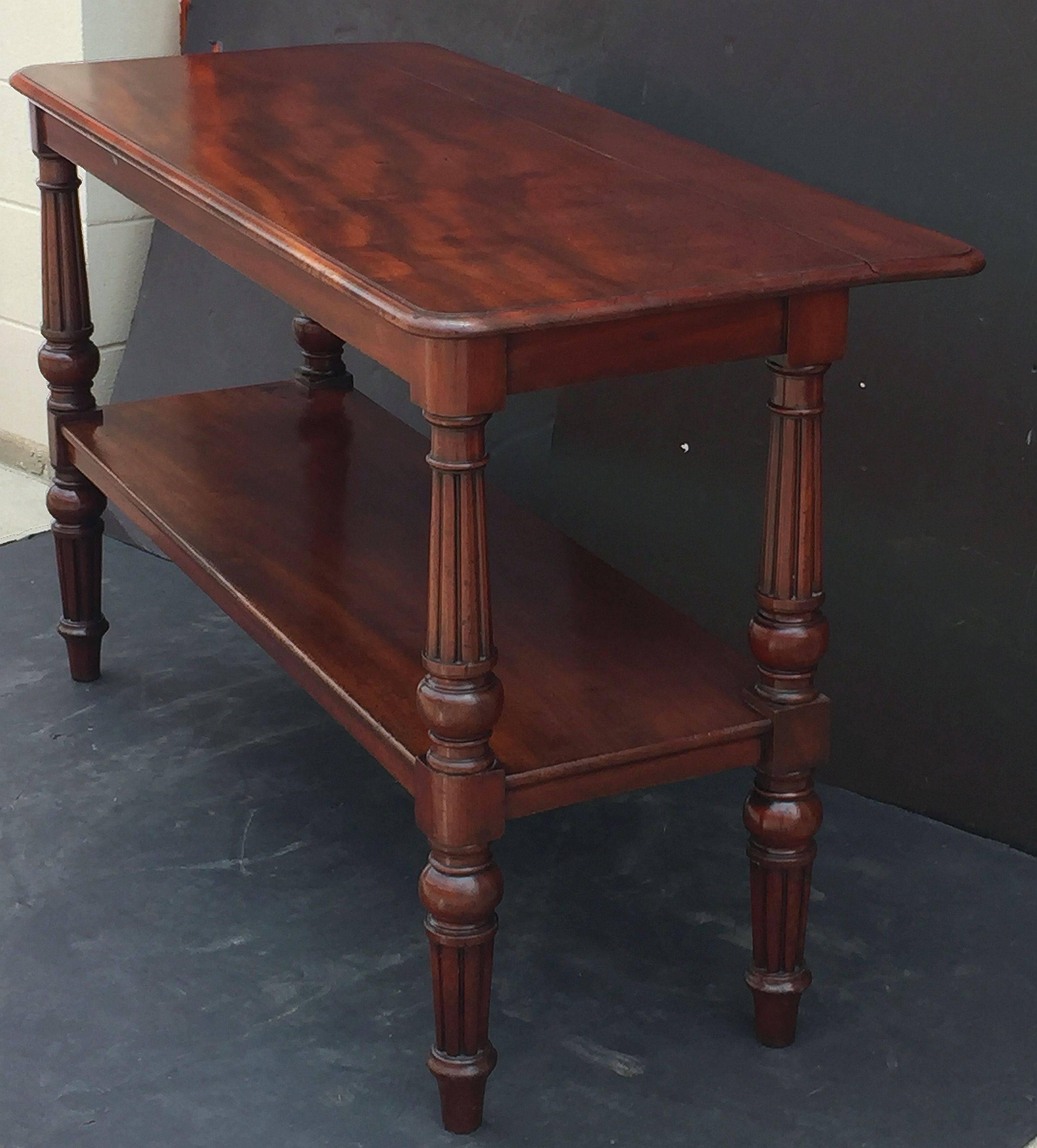 A fine English console server or buffet trolley table of flame mahogany from the William IV era, featuring a moulded rectangular top with extension or leaf to the back, allowing for extra depth. Set upon a frieze of four handsomely turned column