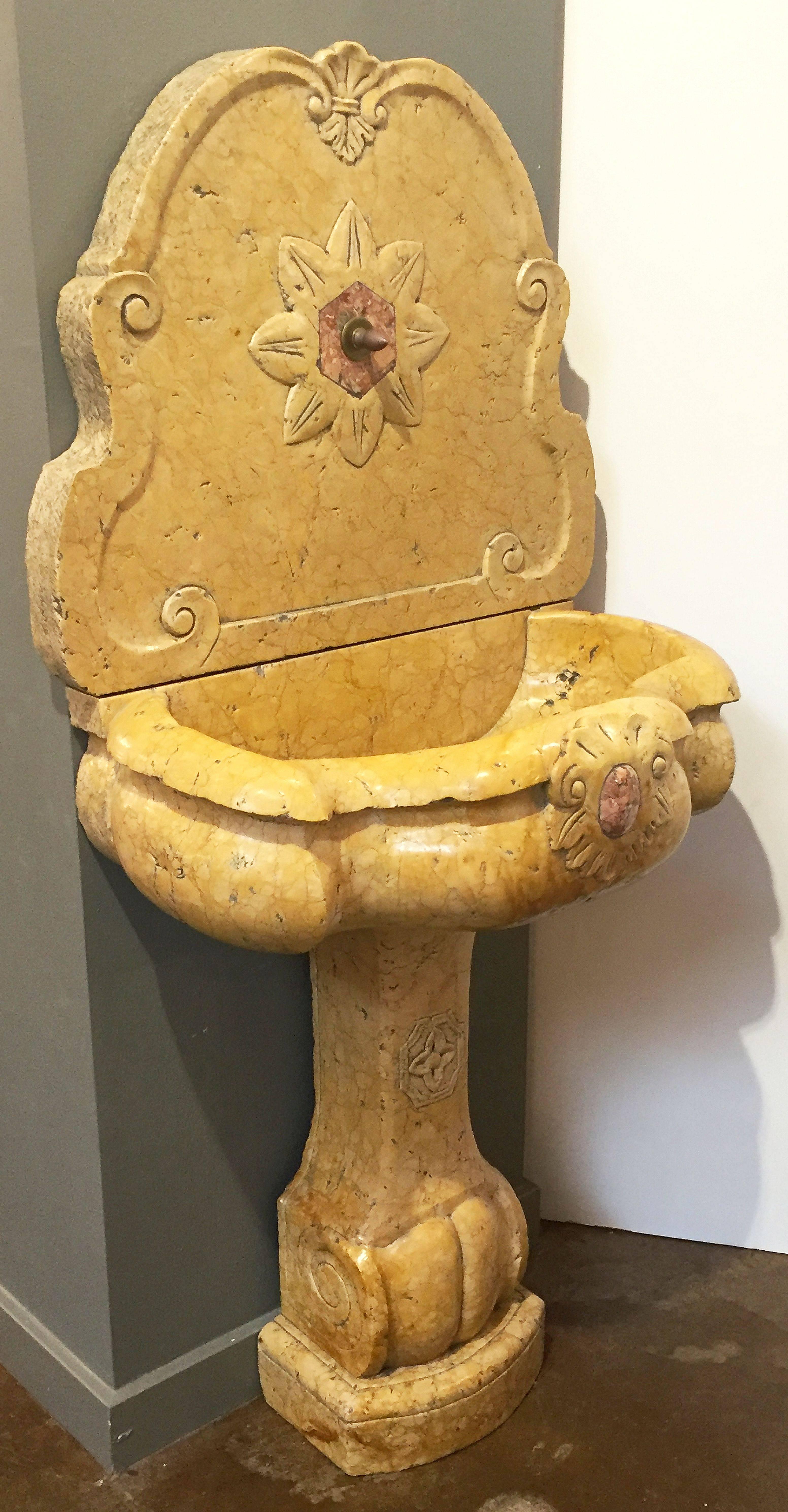A fine Italian standing wall fountain for outdoors or indoors, in three parts - back, basin, and stand - of carved siena marble. Back has hole for mounting fountain-head and basin has hole for drainage.