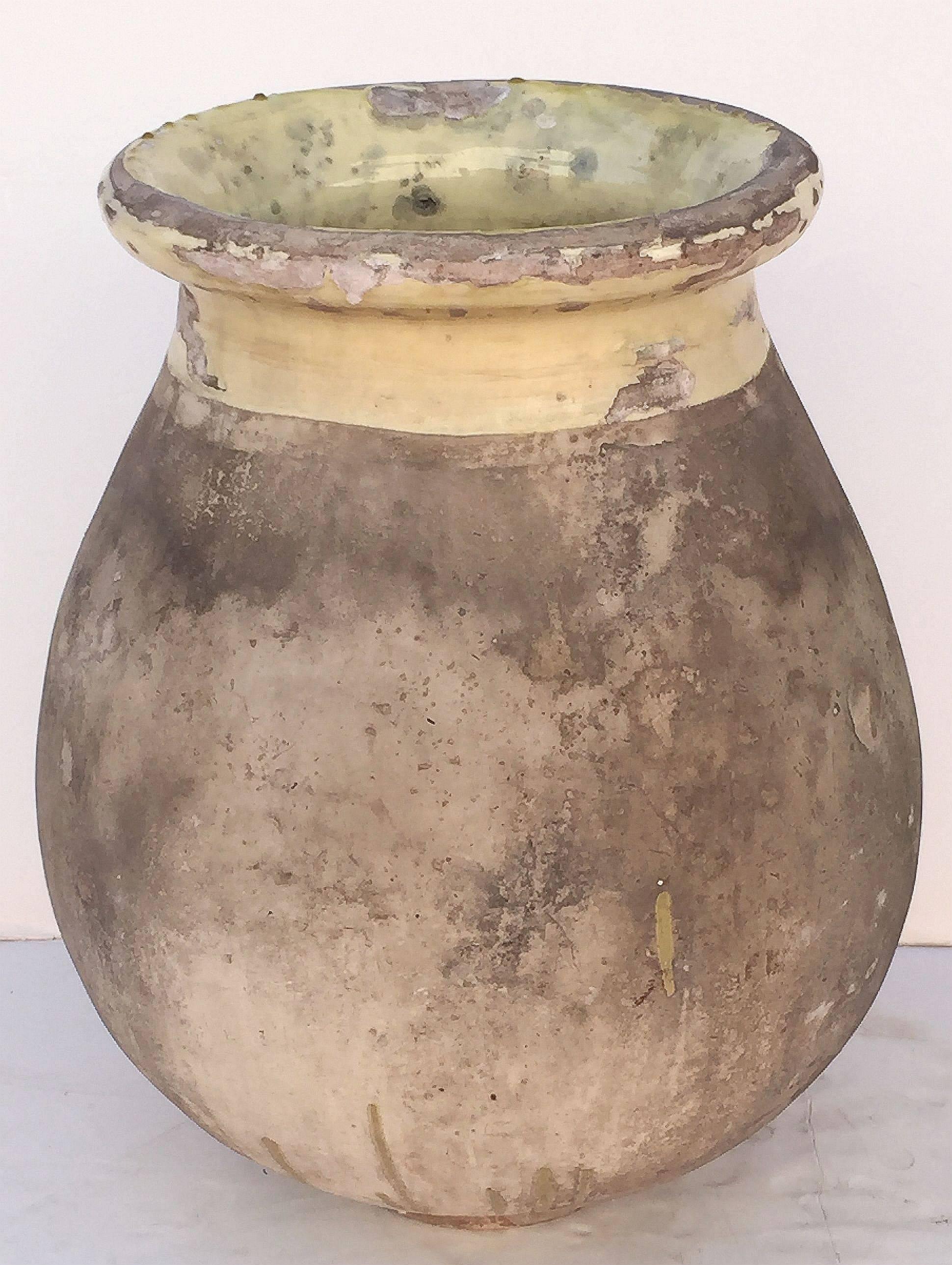 A handsome French garden pot or oil jar from the Biot, Alpes-Maritimes, region known as a pottery center from the 18th century onward.

Featuring a glazed rolled-edge top over a smooth, cylindrical body and functional as a garden ornament, fountain,
