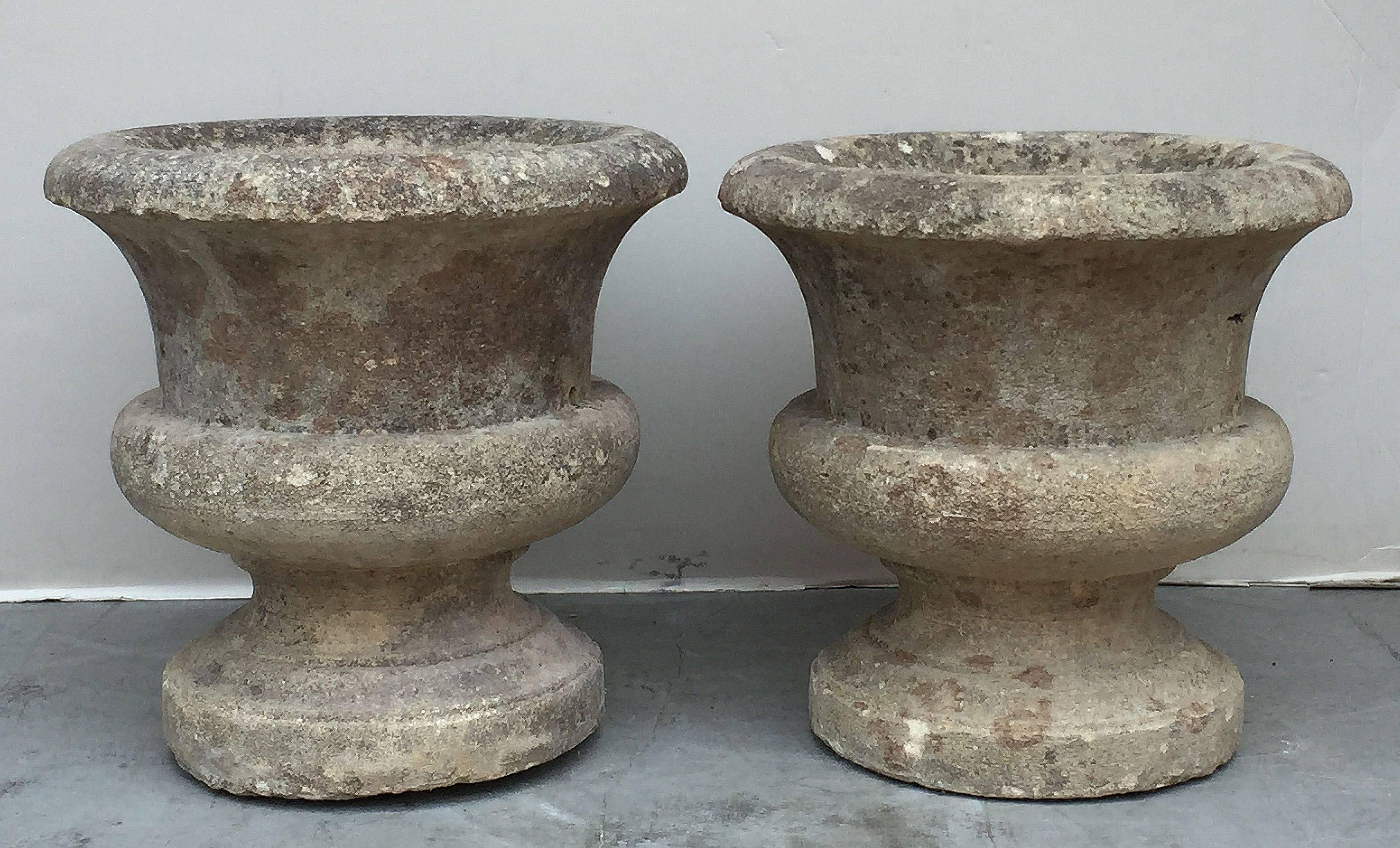 A fine pair of large French round garden planters or pots, each featuring a flared opening around the circumferences at the mid-level and the bottom, set upon a raised base.

Individually priced - $2295 each planter

Perfect for a garden room or