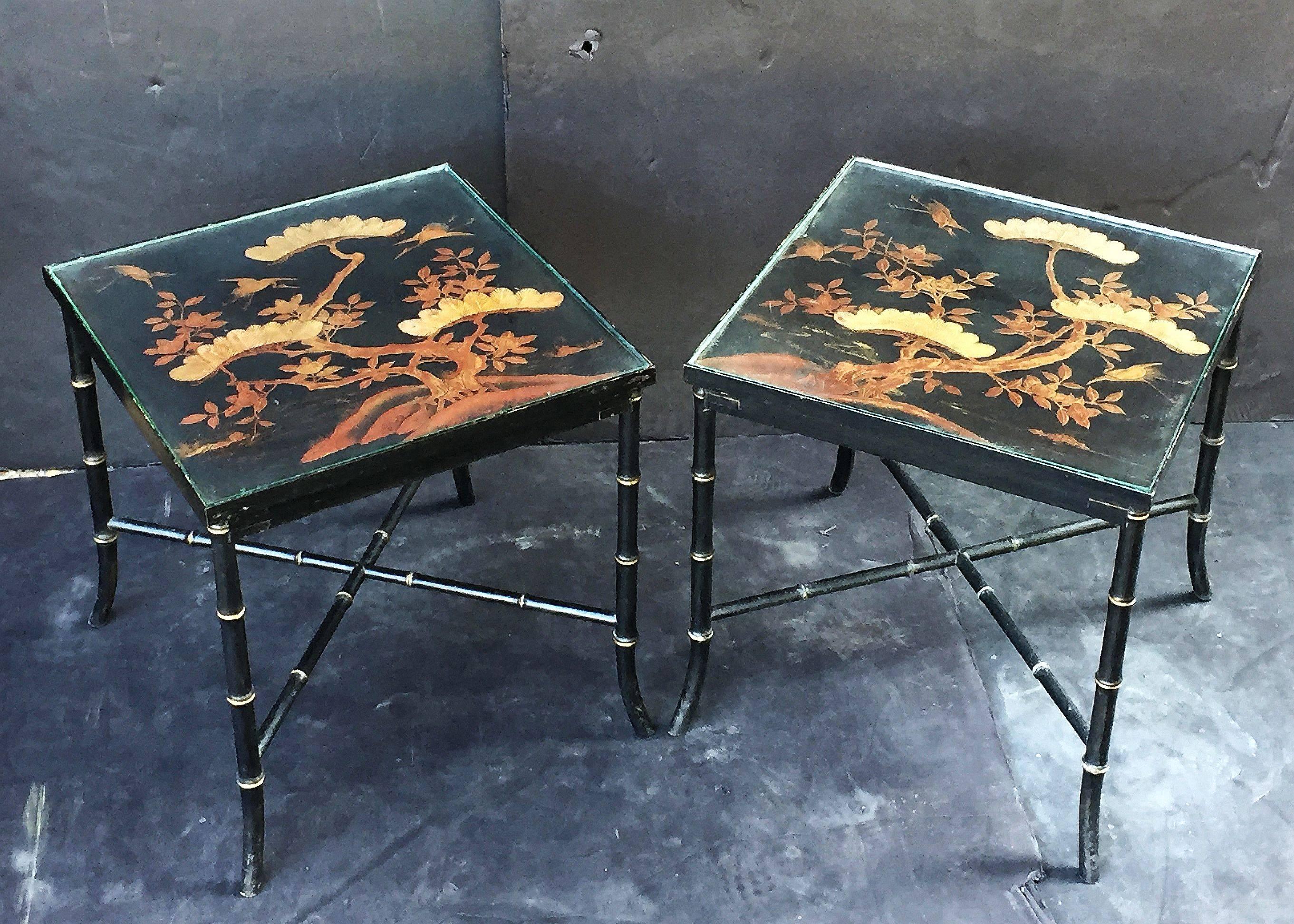 A fine pair of English low (coffee or cocktail) tables, each table featuring a square inset top with a japan-lacquered chinoiserie design of trees and birds, topped with a removable glass insert, and set upon an ebonized four-legged stretcher base,