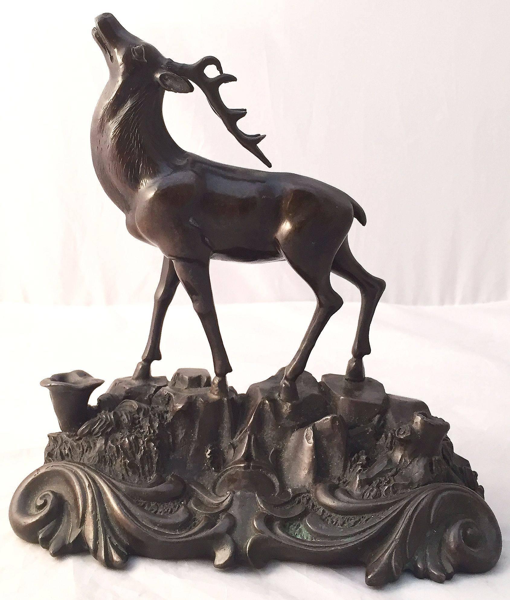 A fine French bronze statue of a deer or stag featuring fine modeling in the round, on scroll-work base.