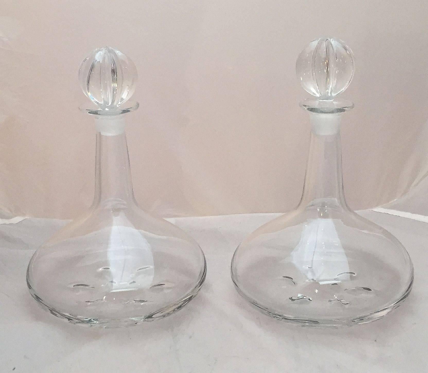 A fine pair of large crystal drinks decanters or ship's decanters for wine, whiskey, and spirits, designed by Nils Landberg for Orrefors, Sweden, who worked for the firm from 1927-1972. 
Each decanter with an elegant modern or mid-century design