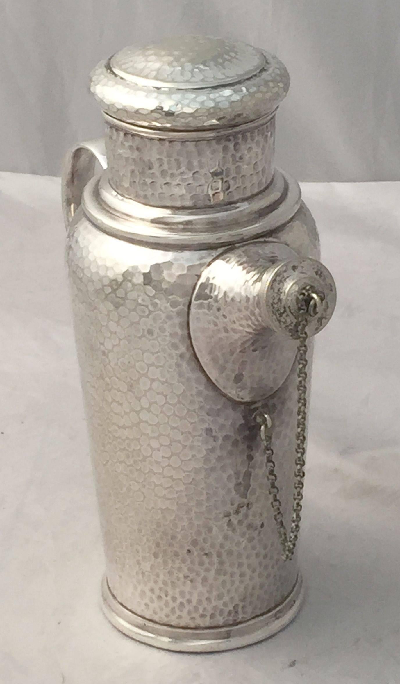 A handsome vintage English cocktail shaker of fine plate silver by William R. Shirtcliffe & Son, Sheffield, featuring a planished or hammered body, with removable corked top, removable corked cap with chain for spout and large handle to