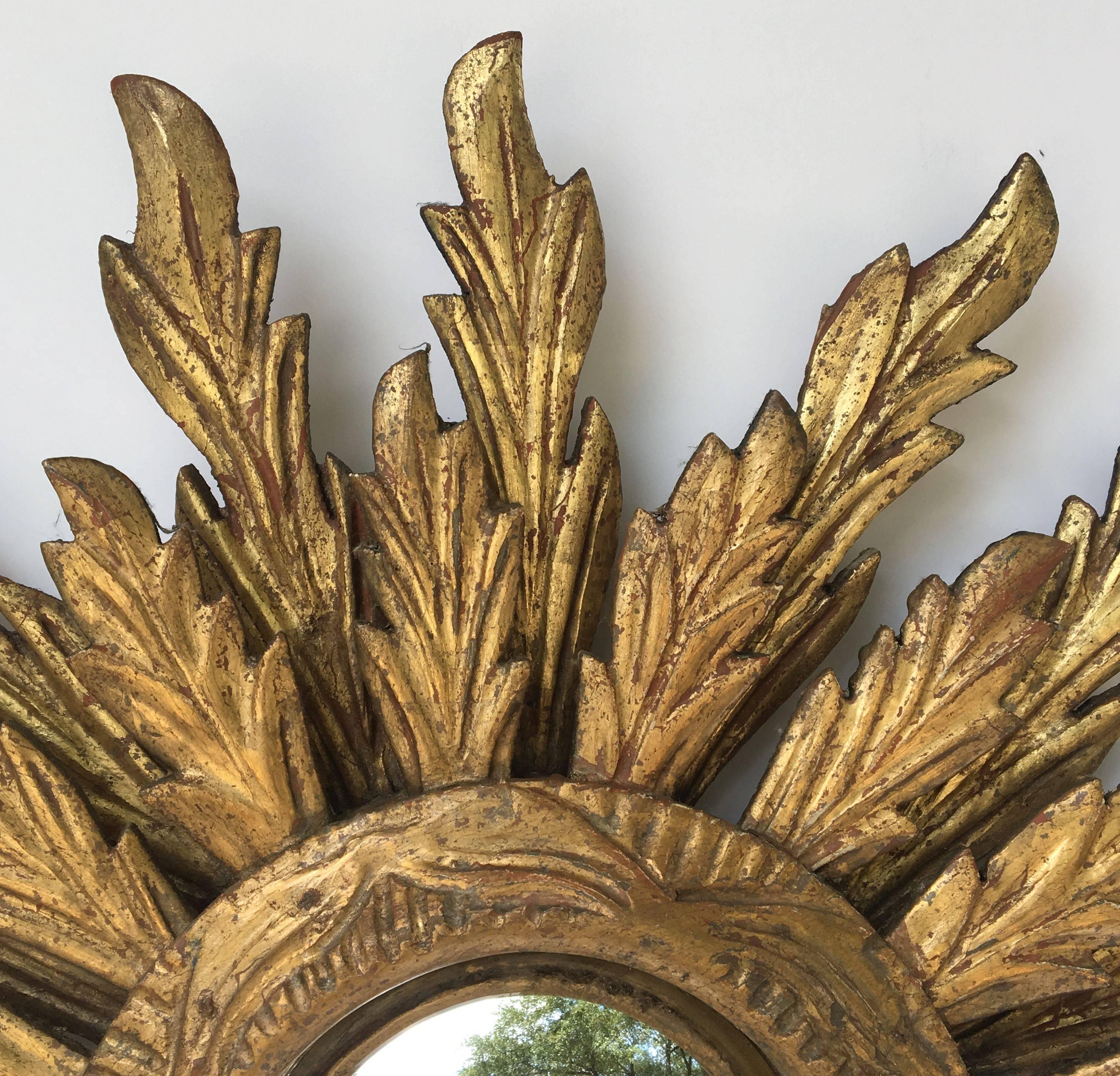 A lovely French gilt sunburst (or starburst) mirror, 24 inches diameter, with convex mirrored glass center in moulded frame.