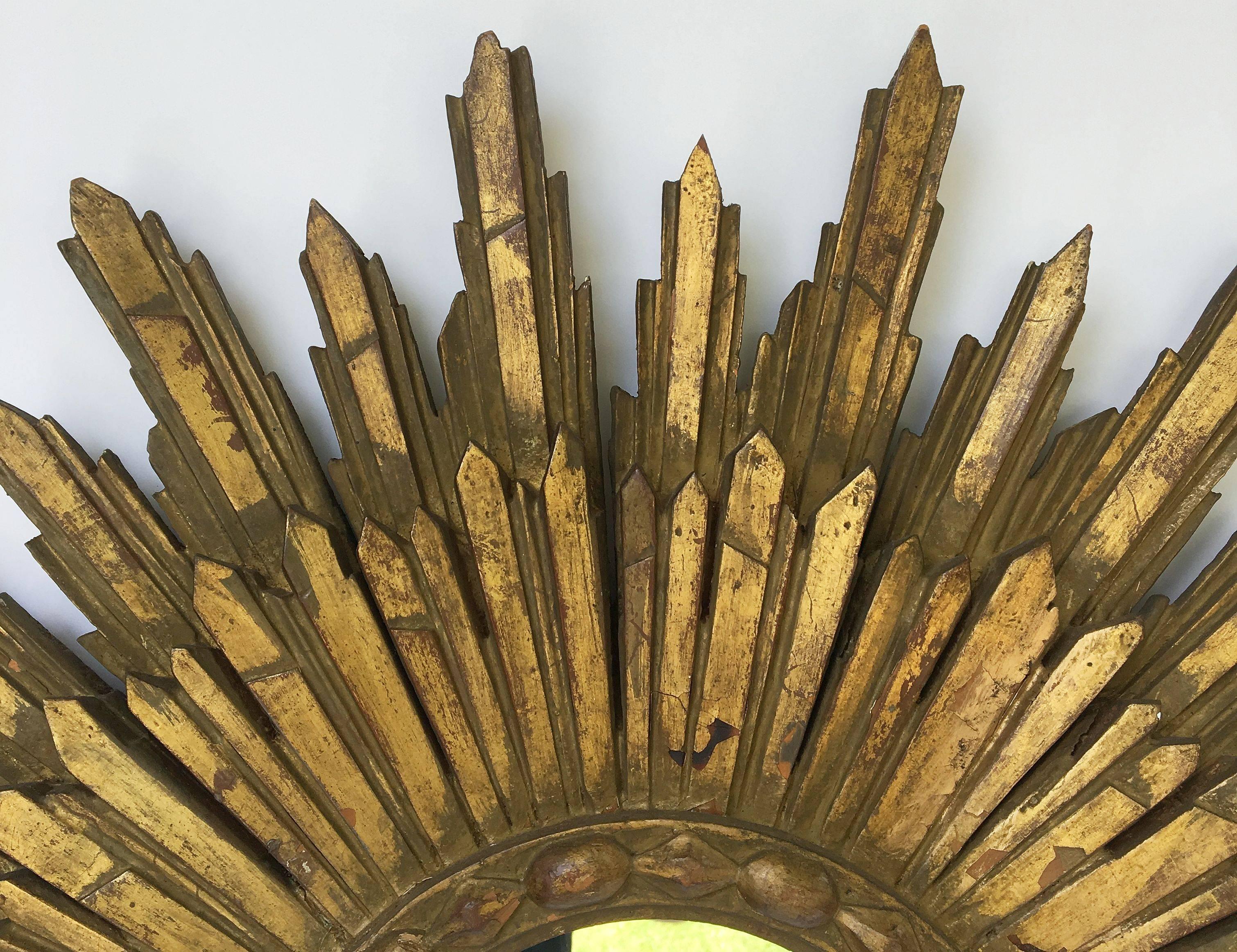 A lovely French gilt sunburst (or starburst) mirror, 29 inches diameter, with mirrored glass center in moulded frame.