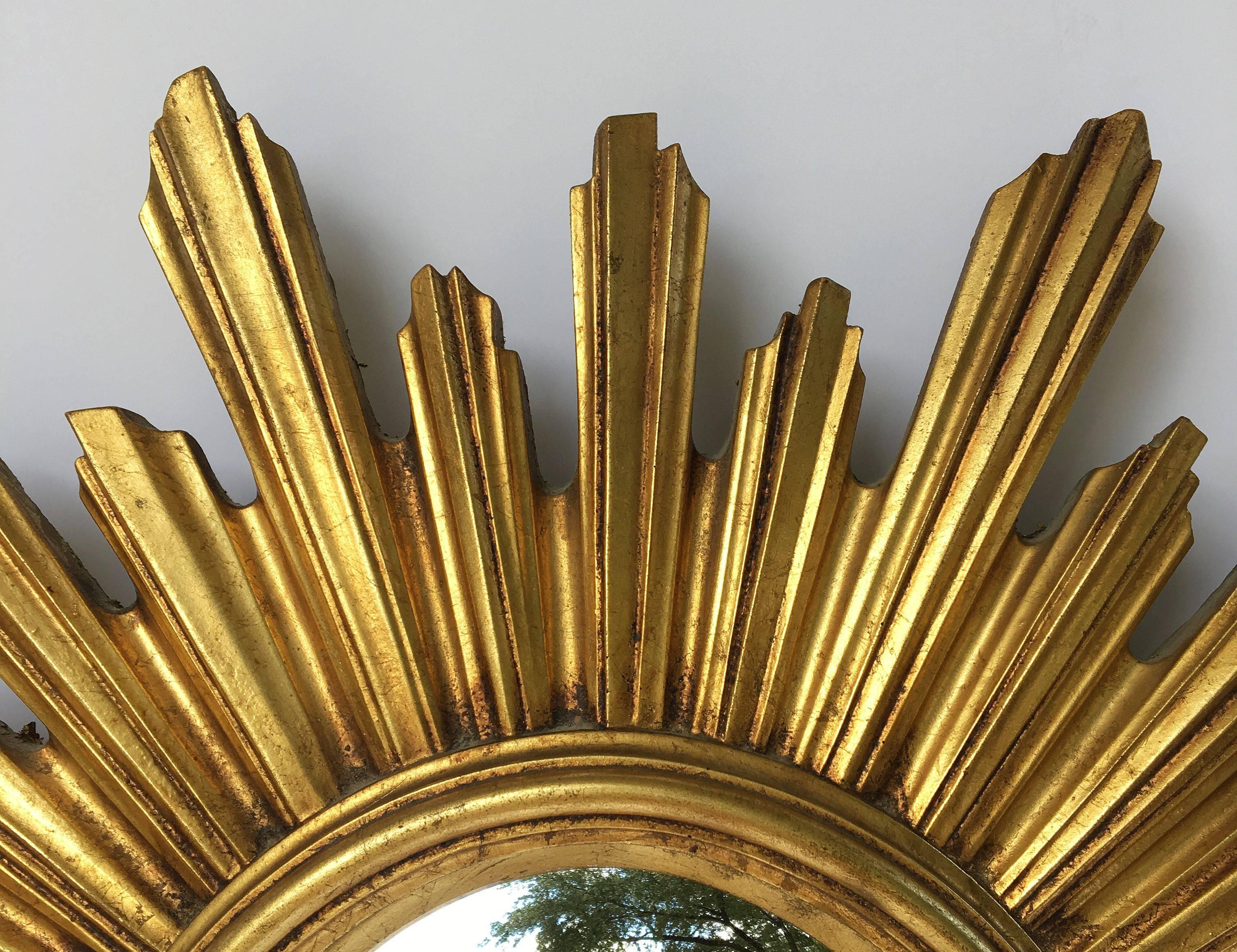 A lovely French gilt sunburst (or starburst) mirror, 21 1/4 inches diameter, with convex mirrored glass centre in moulded frame.
