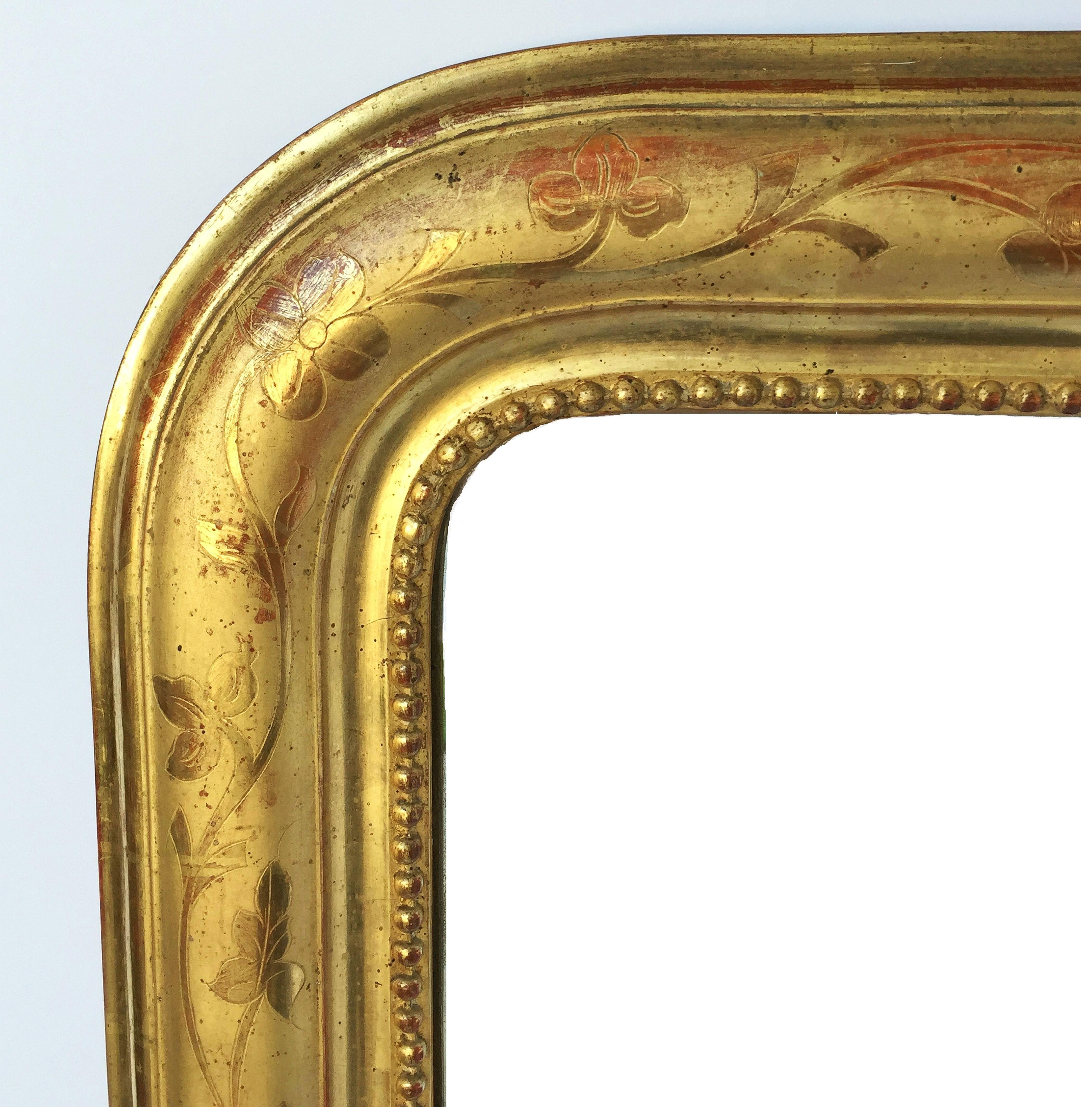A handsome large Louis Philippe gilt wall mirror from France, featuring a lovely moulded surround and an etched foliate design showing through gold-leaf.

Dimensions: H 50 1/2 inches x W 29 1/2 inches.

Other sizes available in this style.