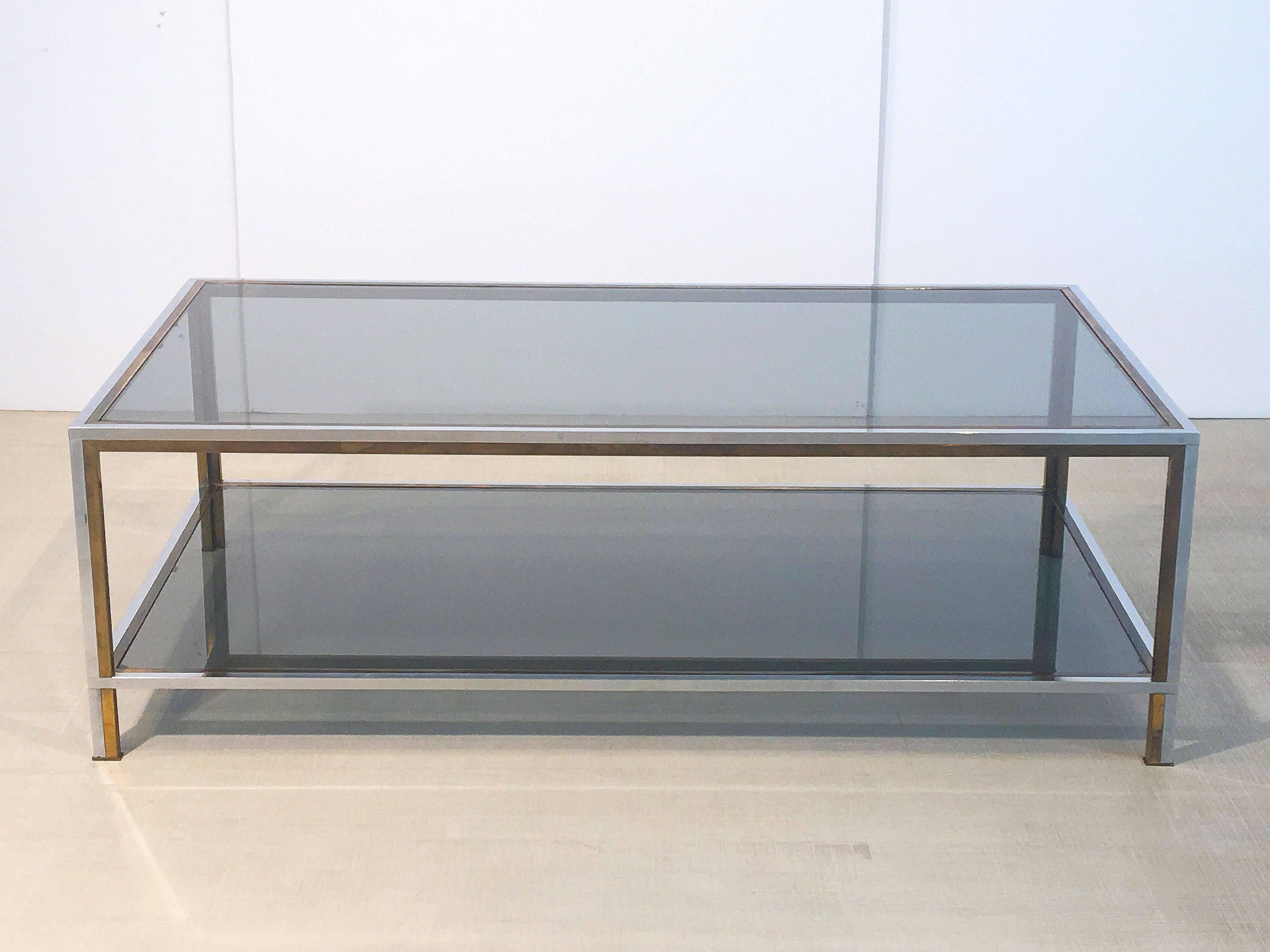 A handsome large French rectangular two-tiered low table (or cocktail table) of chrome, brass, and smoked glass.