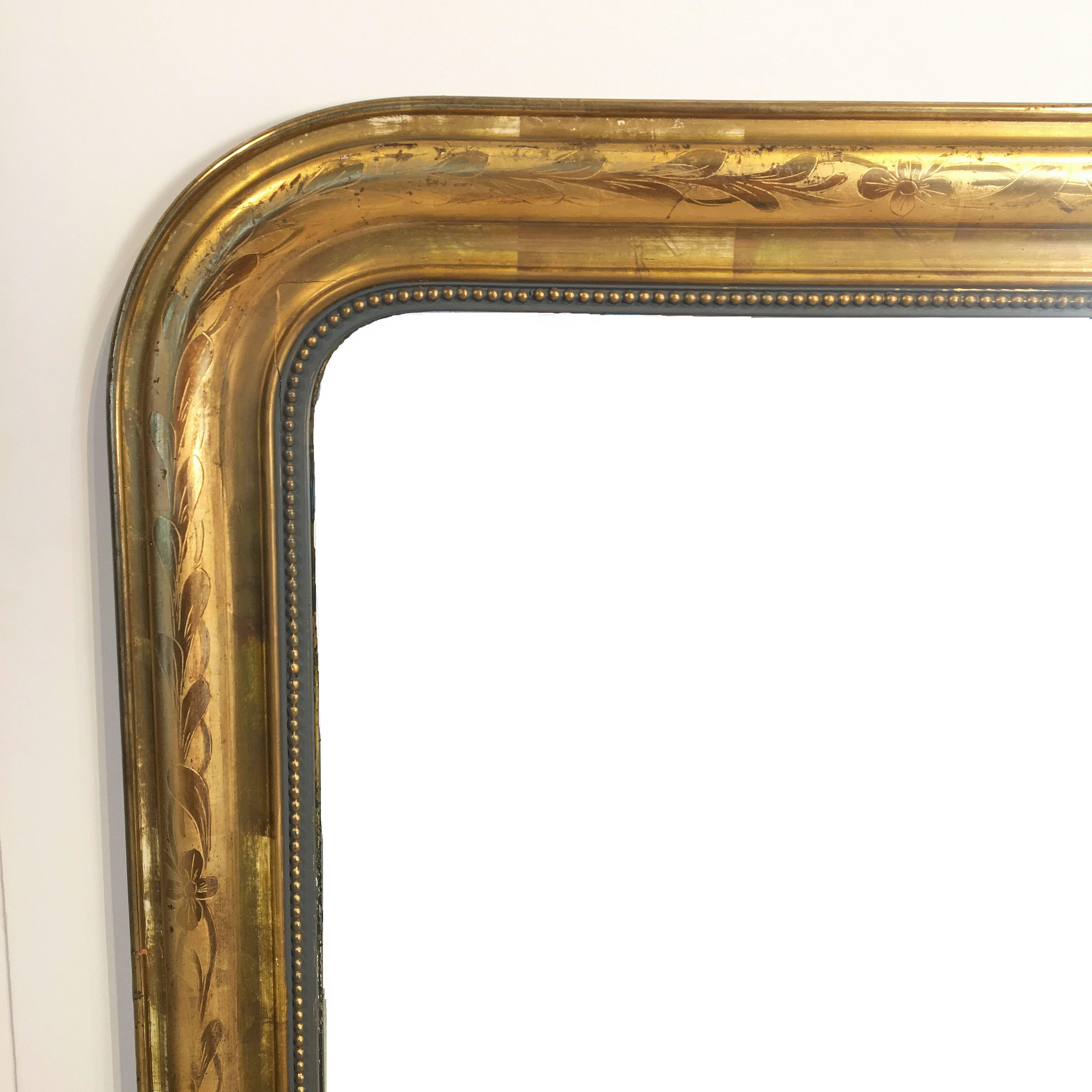 A handsome large Louis Philippe gilt wall mirror from France, featuring a lovely moulded surround and an etched foliate design showing through gold-leaf.

Dimensions: H 55 1/4 inches x W 39 3/4 inches

Other sizes available in this style.